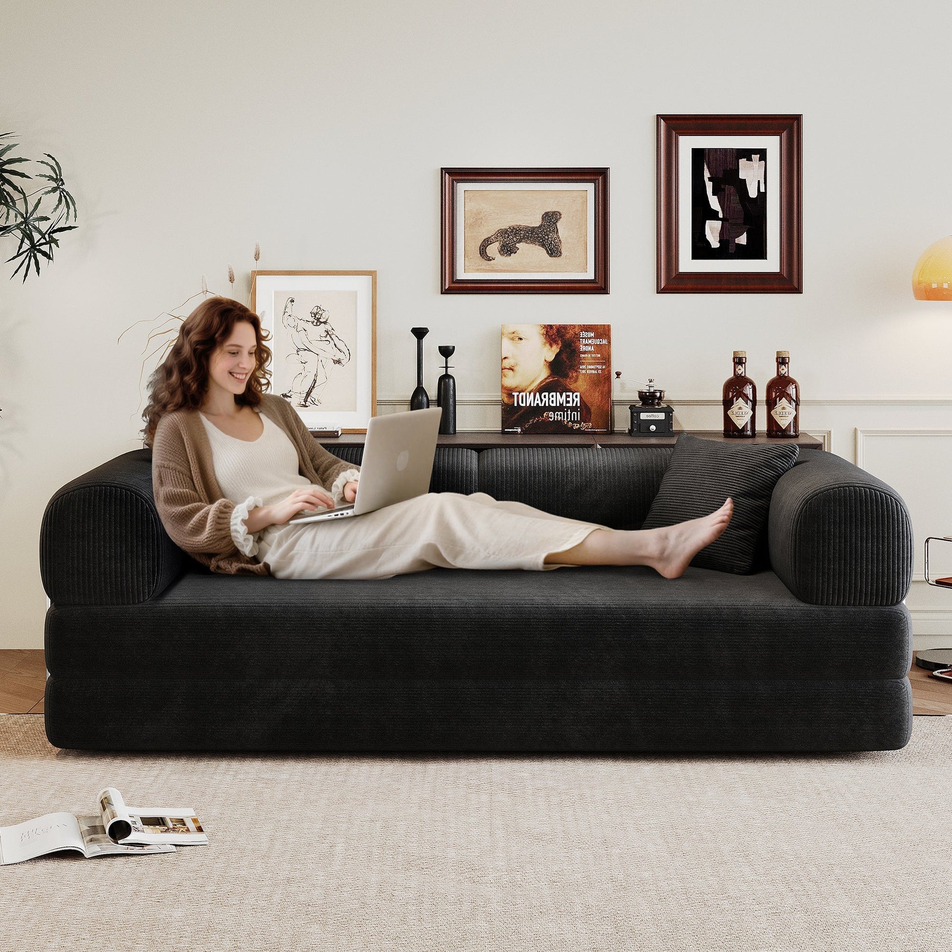 Black corduroy sofa with back and rounded arms, person lounging with laptop in living room on Tampa Home & Garden Store