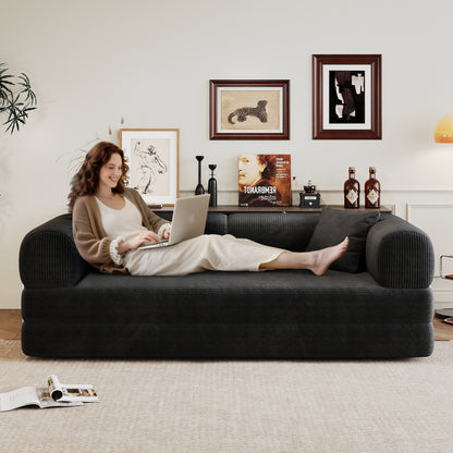 Black corduroy sofa with back and rounded arms, person lounging with laptop in living room on Tampa Home & Garden Store
