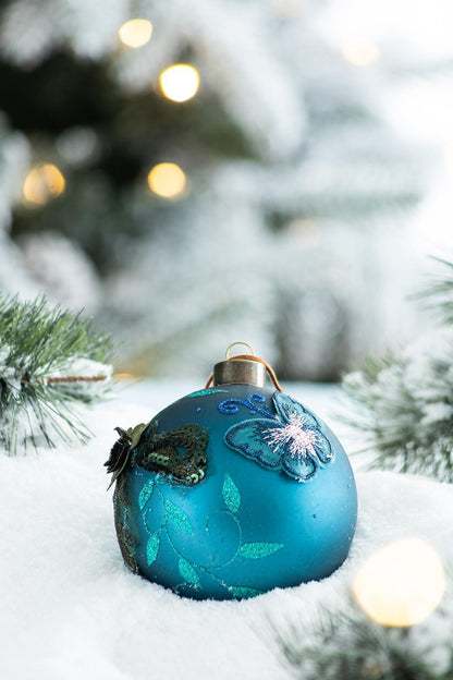 Blue glass Christmas ball ornament with embroidered butterfly and teal leaf designs on Tampa Home & Garden Store