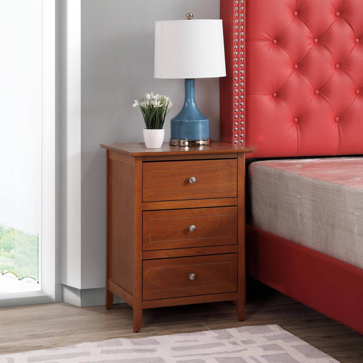 3 Drawer Nightstand in warm brown wood veneer with blue lamp and potted plant beside red tufted headboard on Tampa Home & Garden Store