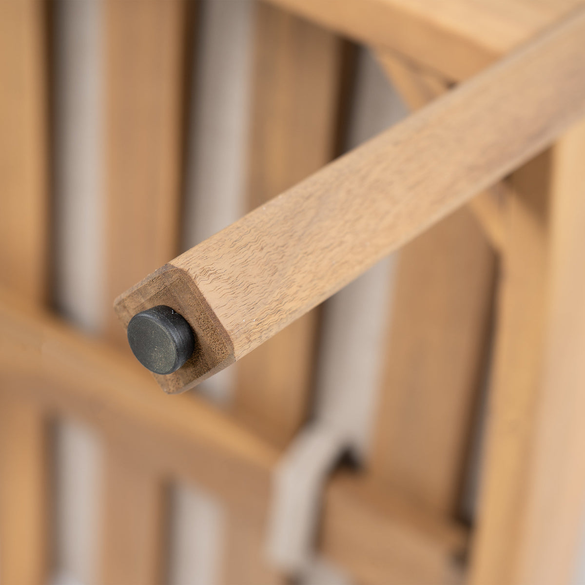 Mallorca acacia wood club chair frame close-up with natural grain and black end cap on Tampa Home & Garden Store
