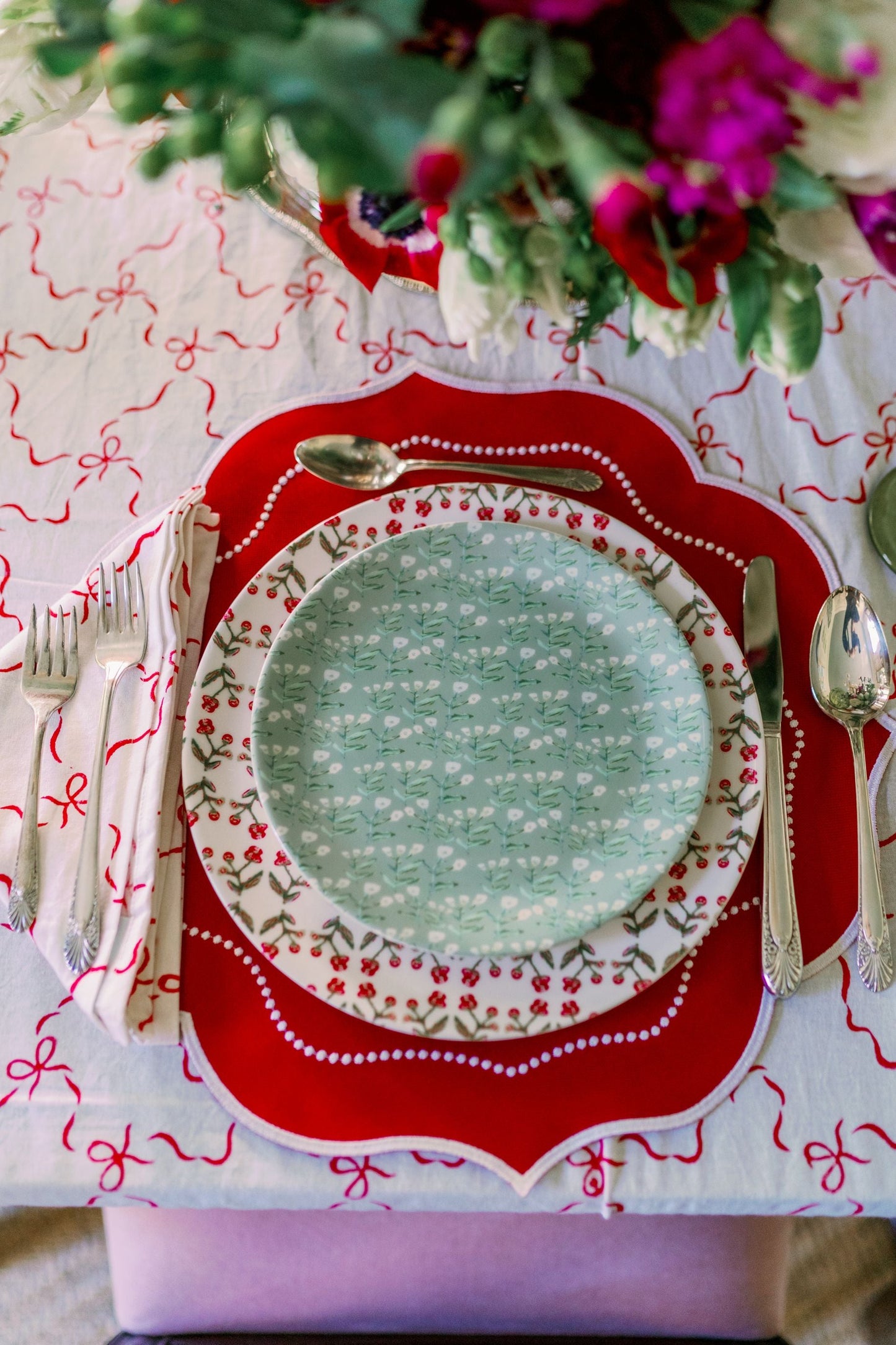 Set of Juniper Sydney China Plates with teal botanical pattern layered on a red charger on Tampa Home & Garden Store
