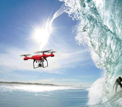 Red X52 RC drone with downward camera flying over sunny ocean beside a curling wave on Tampa Home & Garden Store