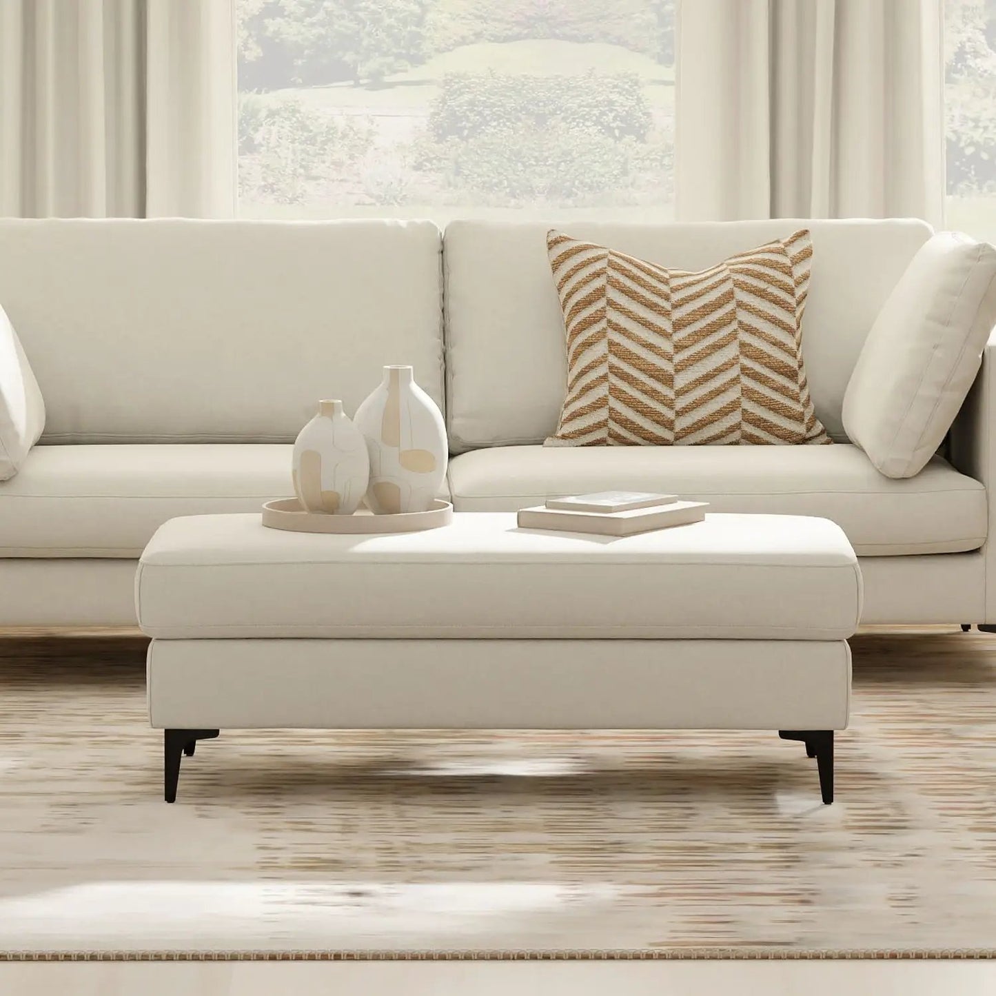 Ava Versatile Mid Century Ottoman in ivory upholstery with slim black legs and a chevron pillow on Tampa Home & Garden Store