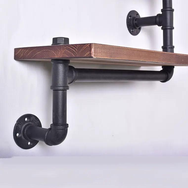 Industrial-style black iron pipe wall shelf with a solid wood plank and flange mounts on Tampa Home & Garden Store