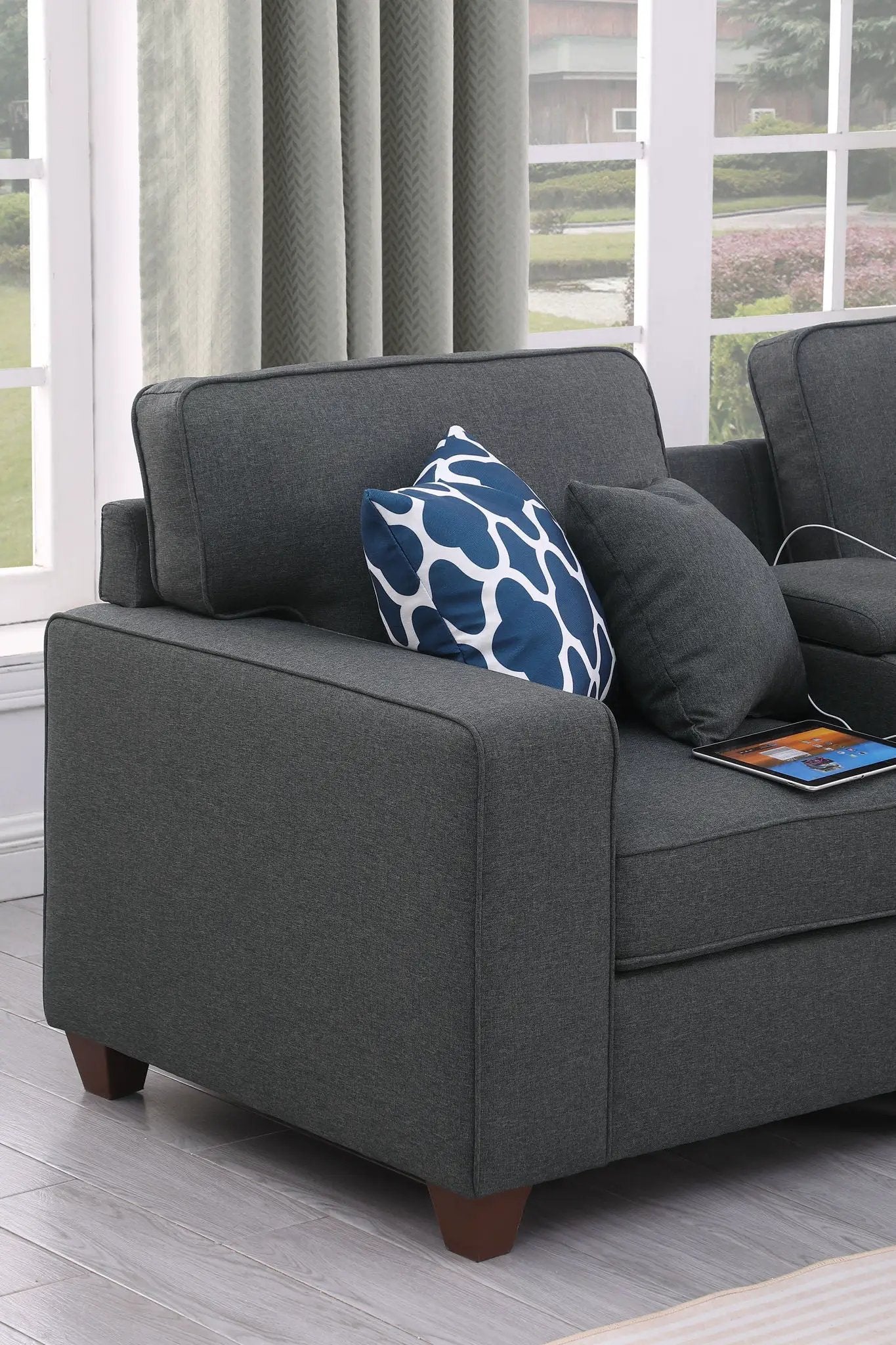 Eric 9-Piece Upholstered Sectional With Ottoman in dark gray fabric with blue geometric pillow on Tampa Home & Garden Store