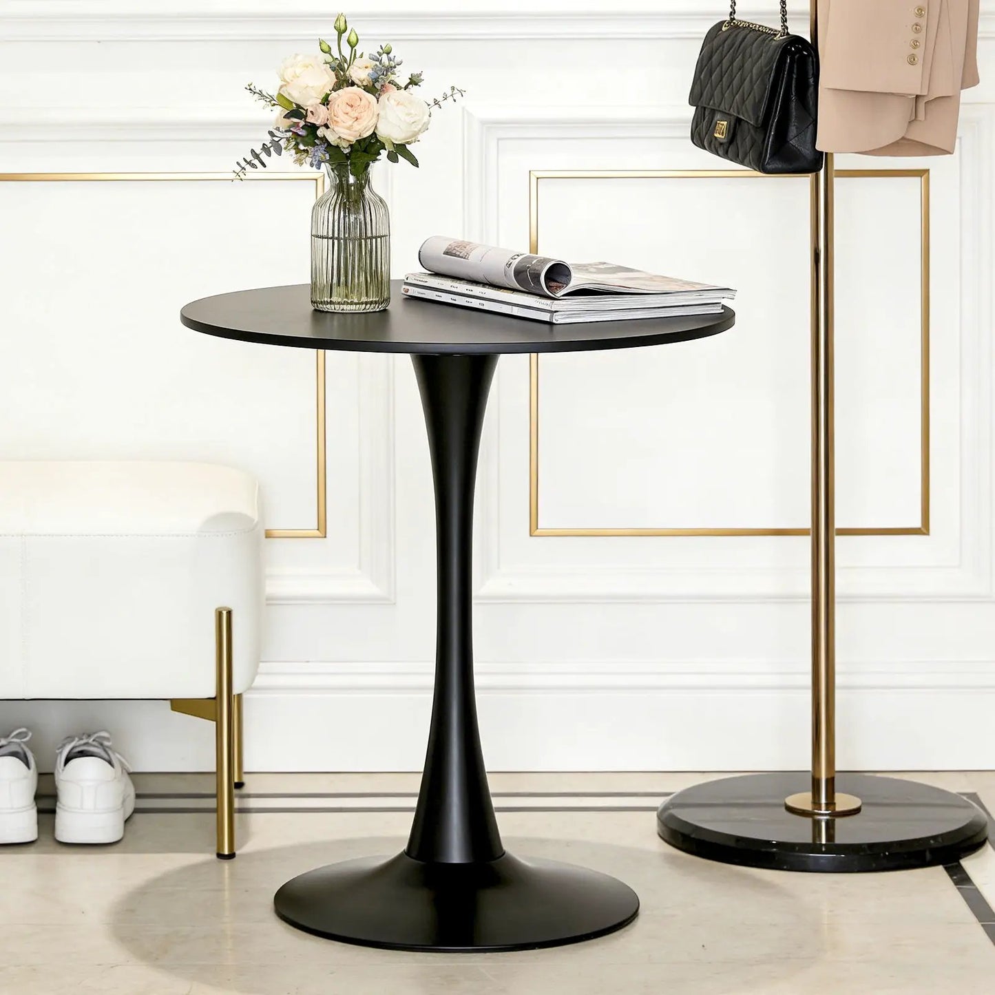 Black round dining table with tulip-style pedestal base, vase of pale roses and magazines on top on Tampa Home & Garden Store