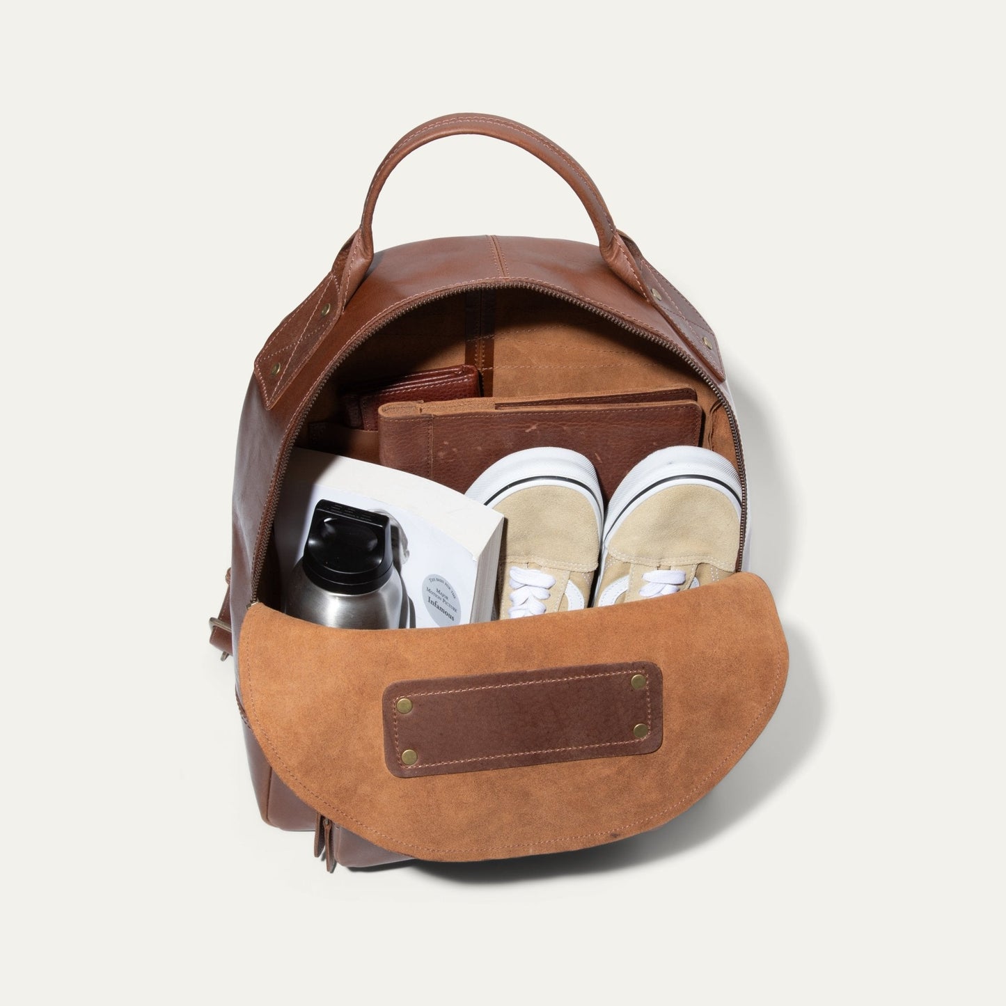 The Field Backpack by Will Leather Goods, brown pack opened to show interior with sneakers on Tampa Home & Garden Store
