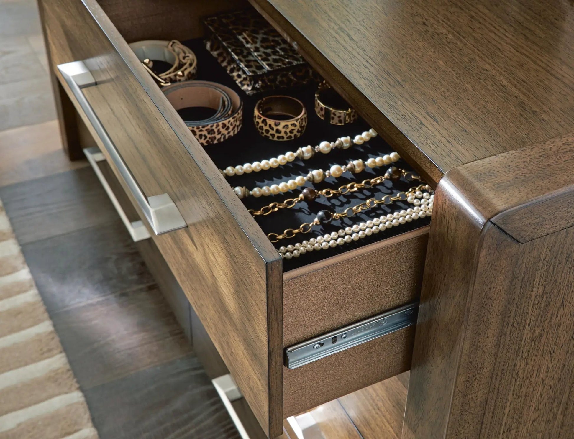 Marxmore dresser in dark wood with open top drawer showing leopard print belts and pearl jewelry on Tampa Home & Garden Store