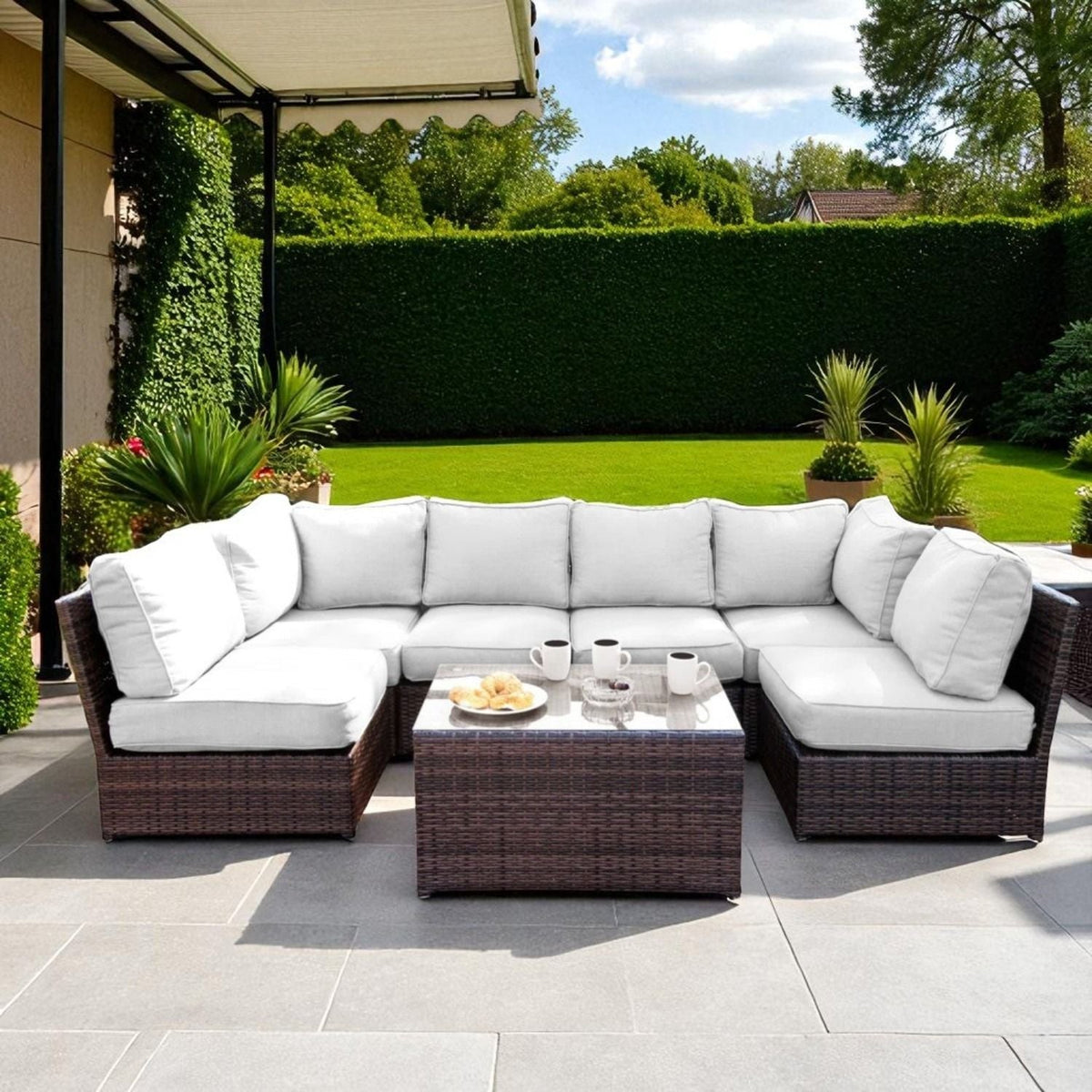Comfortable Modern Patio Rattan Sectional with white cushions and glass-top coffee table on Tampa Home & Garden Store