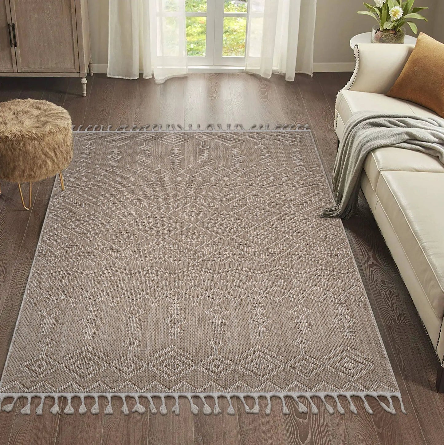 Guros traditional indoor/outdoor area rug beige with diamond motif and fringe tassels on dark wood floor on Tampa Home & Garden Store
