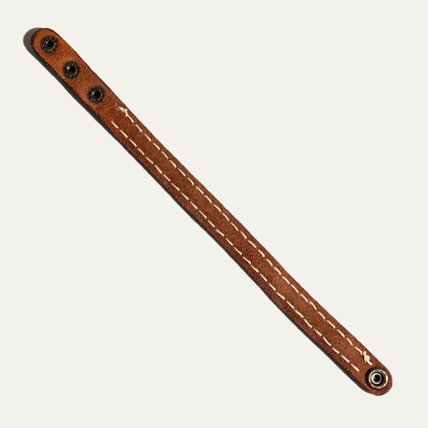Cross Stitch Cuff brown leather wrist bracelet with white stitching and metal snaps on Tampa Home & Garden Store