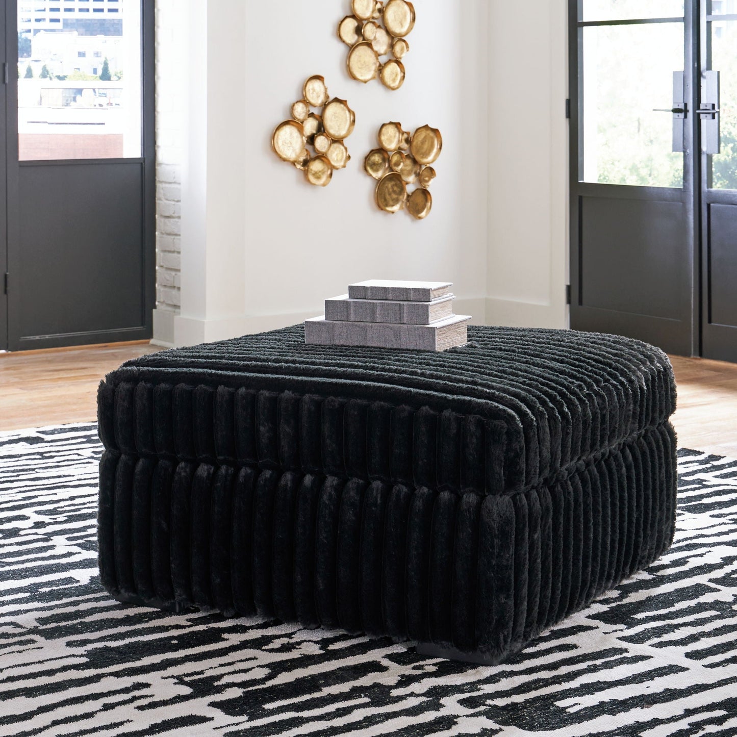 Round black velvet ottoman from Midnight-Madness 4 Piece Set with stacked gray boxes and gold art on Tampa Home & Garden Store