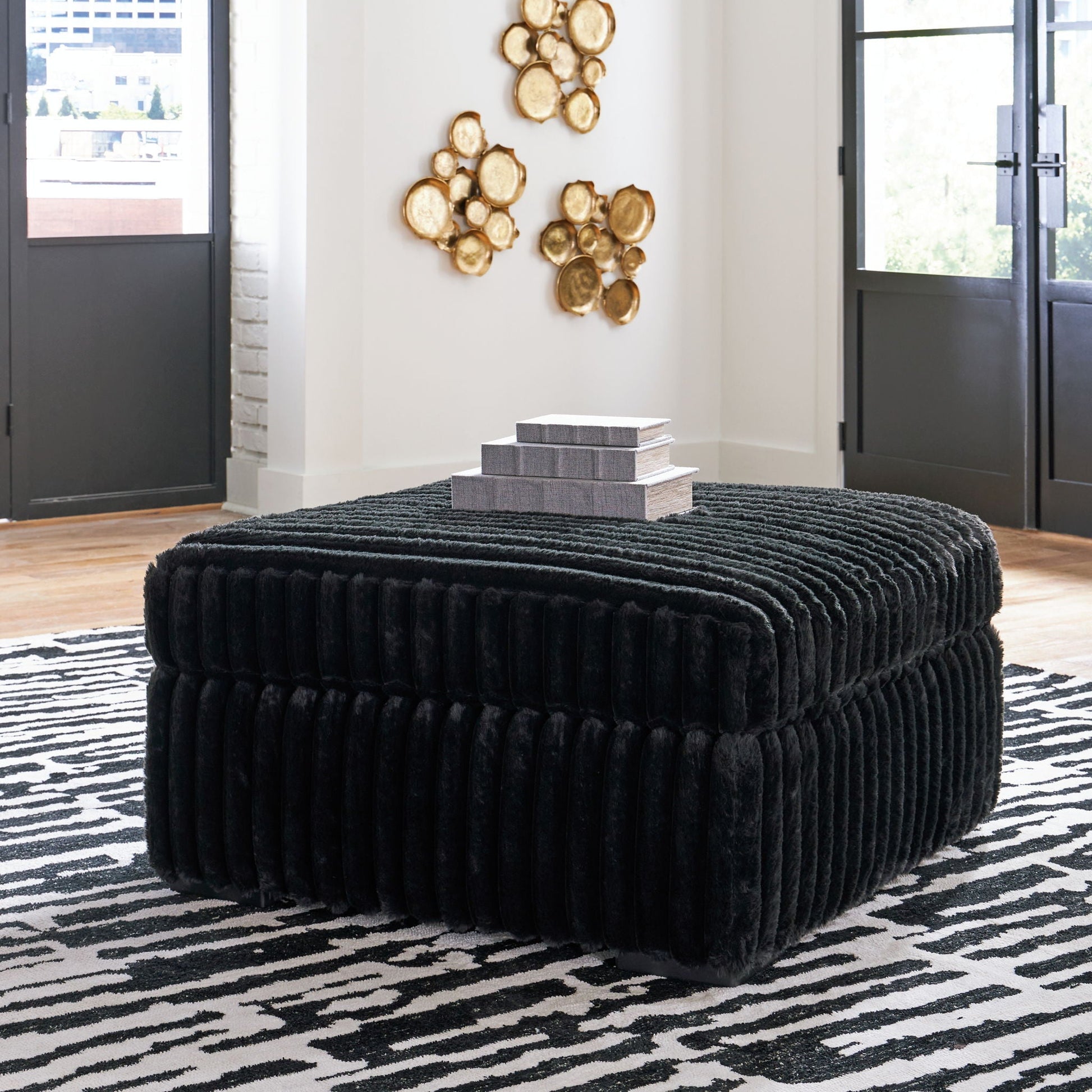 Round black velvet ottoman from Midnight-Madness 4 Piece Set with stacked gray boxes and gold art on Tampa Home & Garden Store