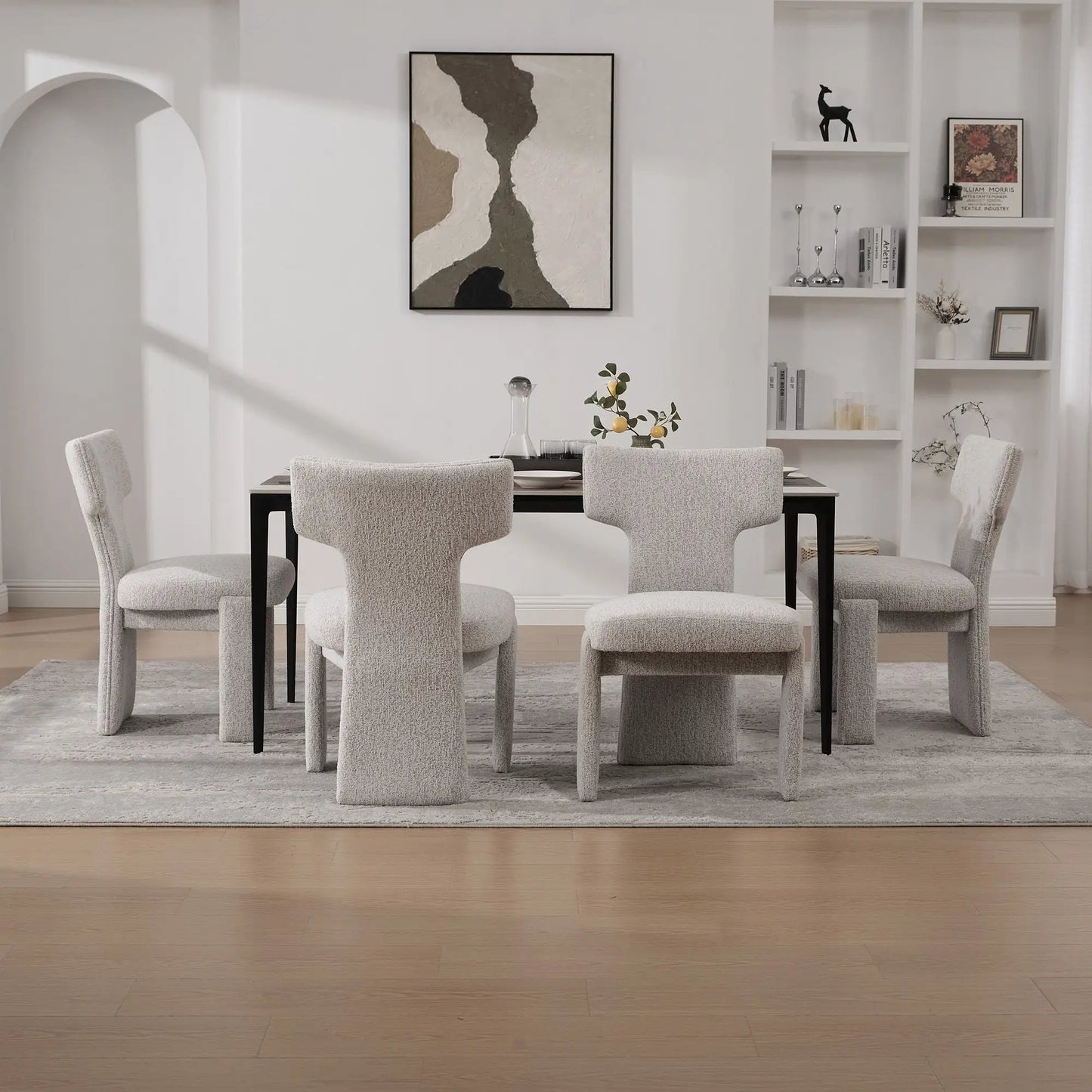 Armless curved-back accent chairs in light gray fabric with black legs around a dining table on Tampa Home & Garden Store