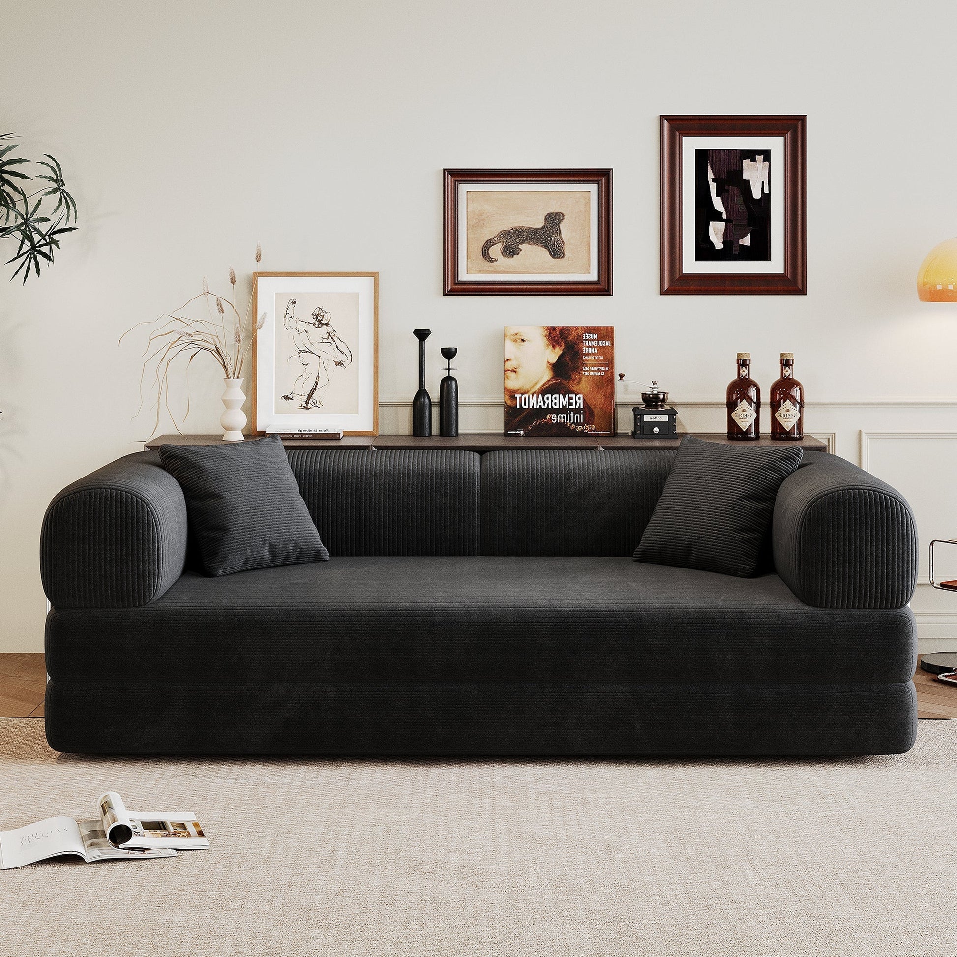 Black corduroy sofa with plush cushions in a living room setup featuring framed art on Tampa Home & Garden Store