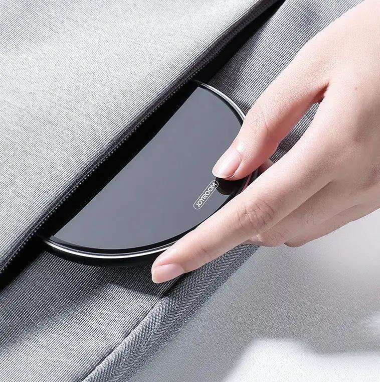 Wireless fast-charge charger pad by JoyRoom, curved black surface with silver rim held by hand on Tampa Home & Garden Store