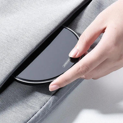 Wireless fast-charge charger pad by JoyRoom, curved black surface with silver rim held by hand on Tampa Home & Garden Store