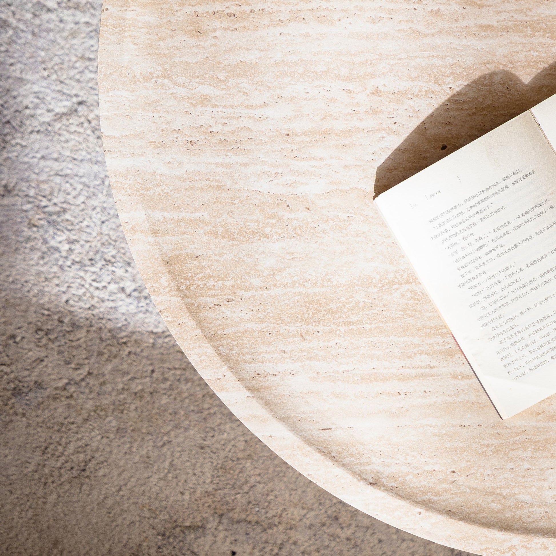 Round coffee table Mars pattern beige stone top with a partially visible book on edge on Tampa Home & Garden Store
