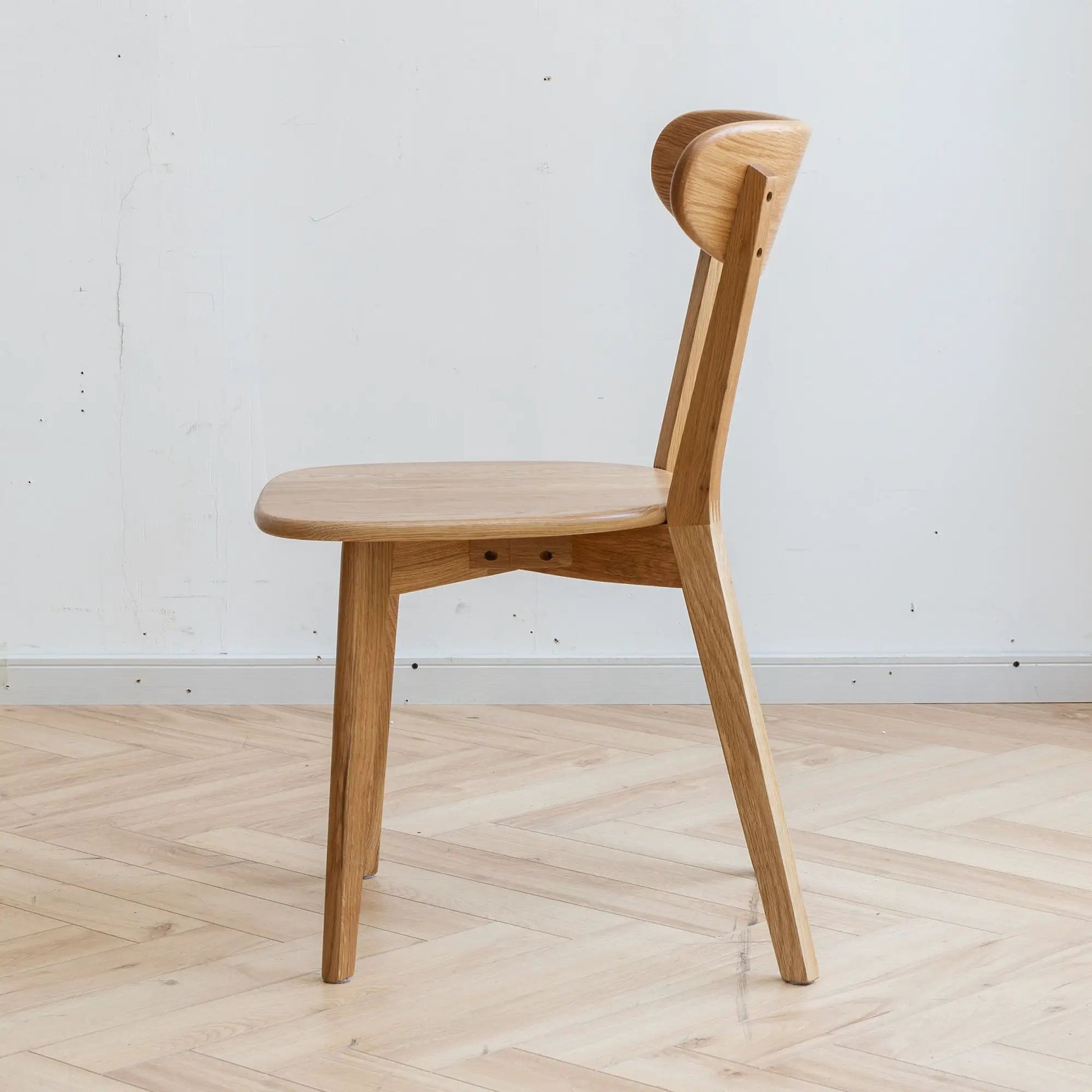 Simple dining chair made of solid wood with natural oak finish, side profile view on Tampa Home & Garden Store