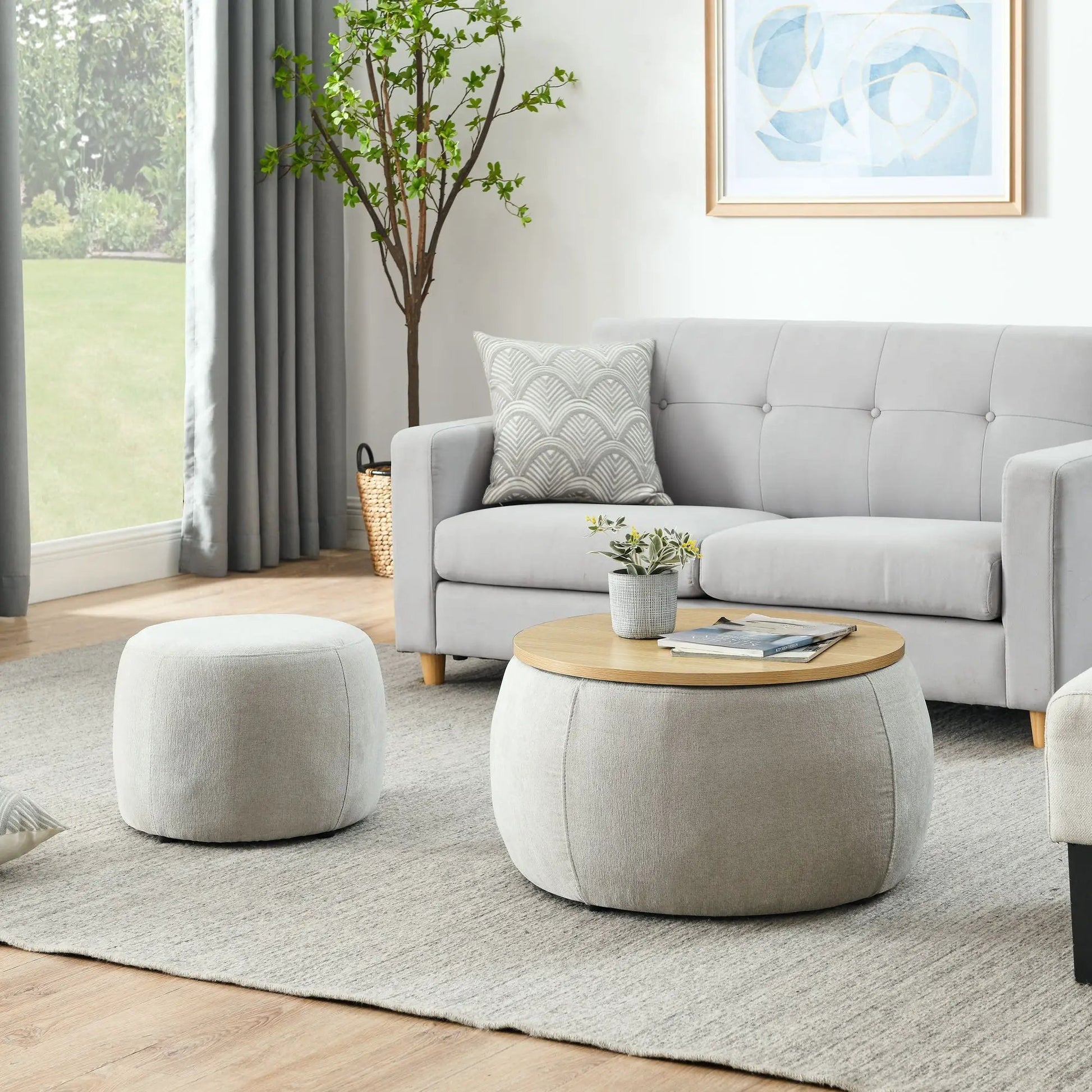 Round storage ottoman with wood-top end table in light gray fabric living room setup on Tampa Home & Garden Store