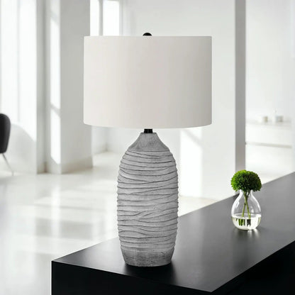 Table lamp with a ribbed gray resin base and cream fabric shade on Tampa Home & Garden Store