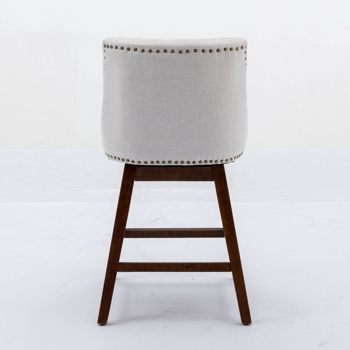 Counter height swivel barstool in beige fabric with brass nailhead trim and dark wood legs on Tampa Home & Garden Store
