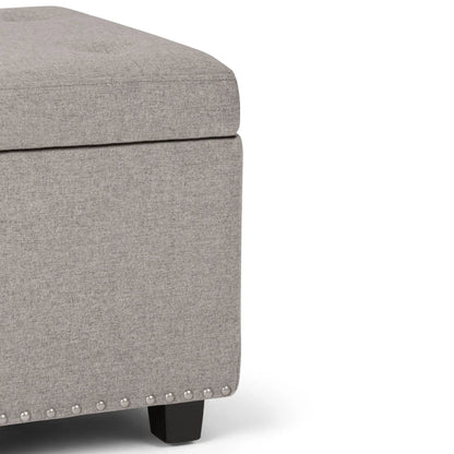 Hamilton upholstered storage ottoman in gray fabric with nailhead trim and dark wood legs on Tampa Home & Garden Store