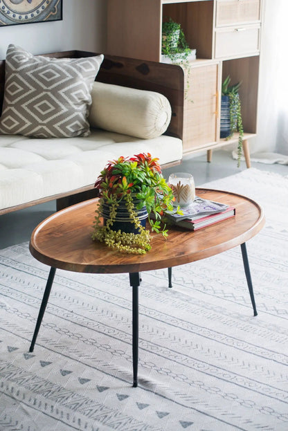 Oval Coffee Table - Brown with wood grain top and black metal hairpin legs in living room on Tampa Home & Garden Store