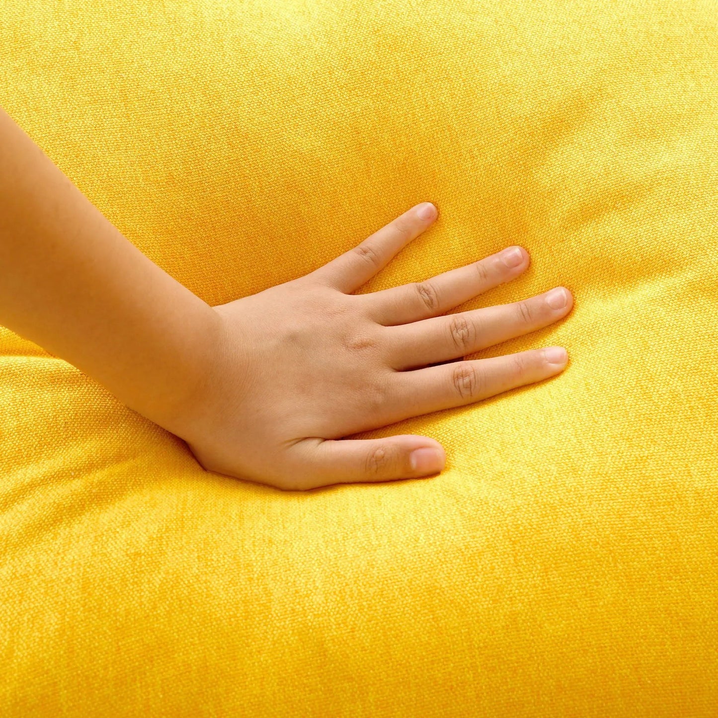Sleeper sectional fabric swatch in bright yellow textured upholstery with a hand for scale on Tampa Home & Garden Store