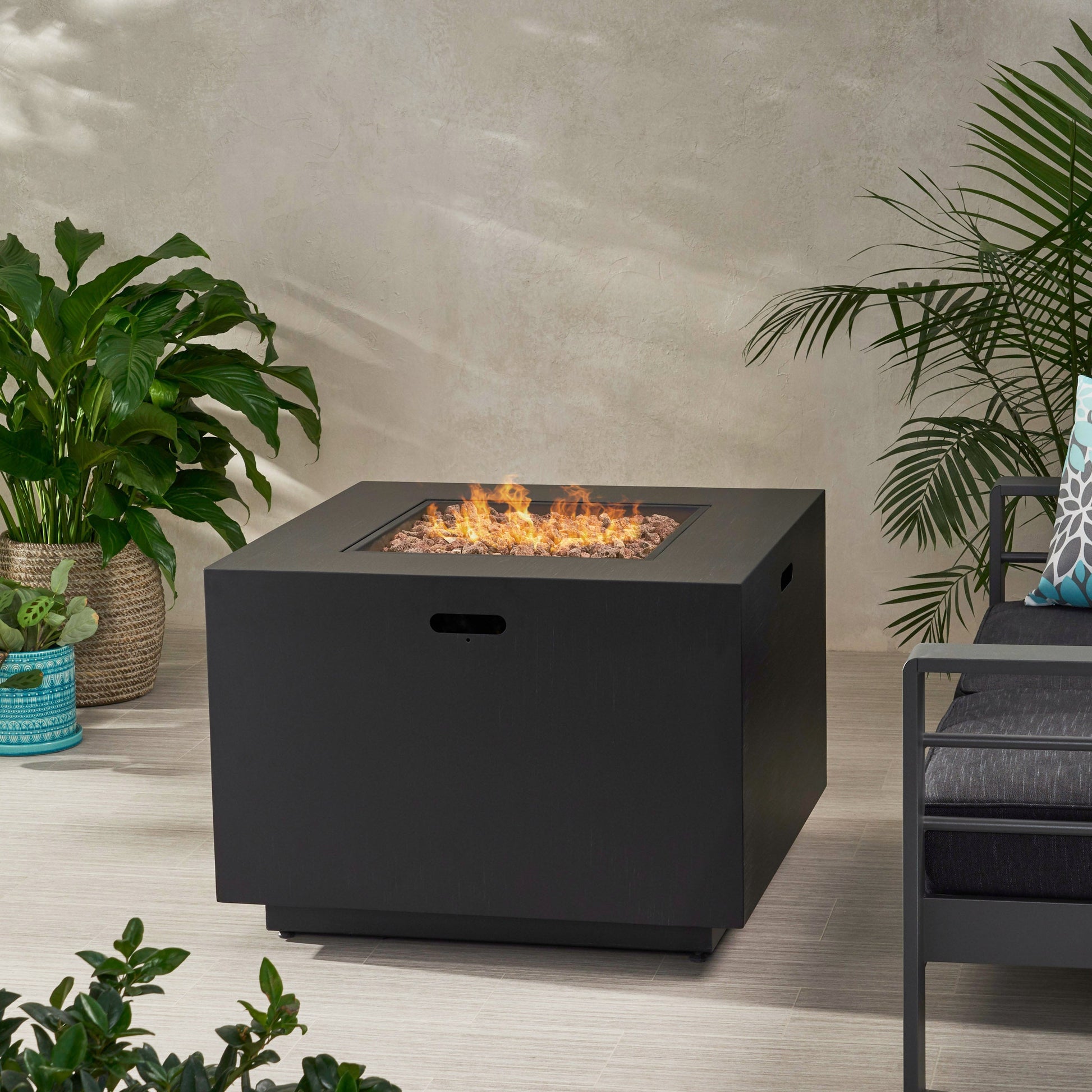 Outdoor square iron gas-burning fire pit, black finish, 24x31 in with flames and lava rocks on Tampa Home & Garden Store