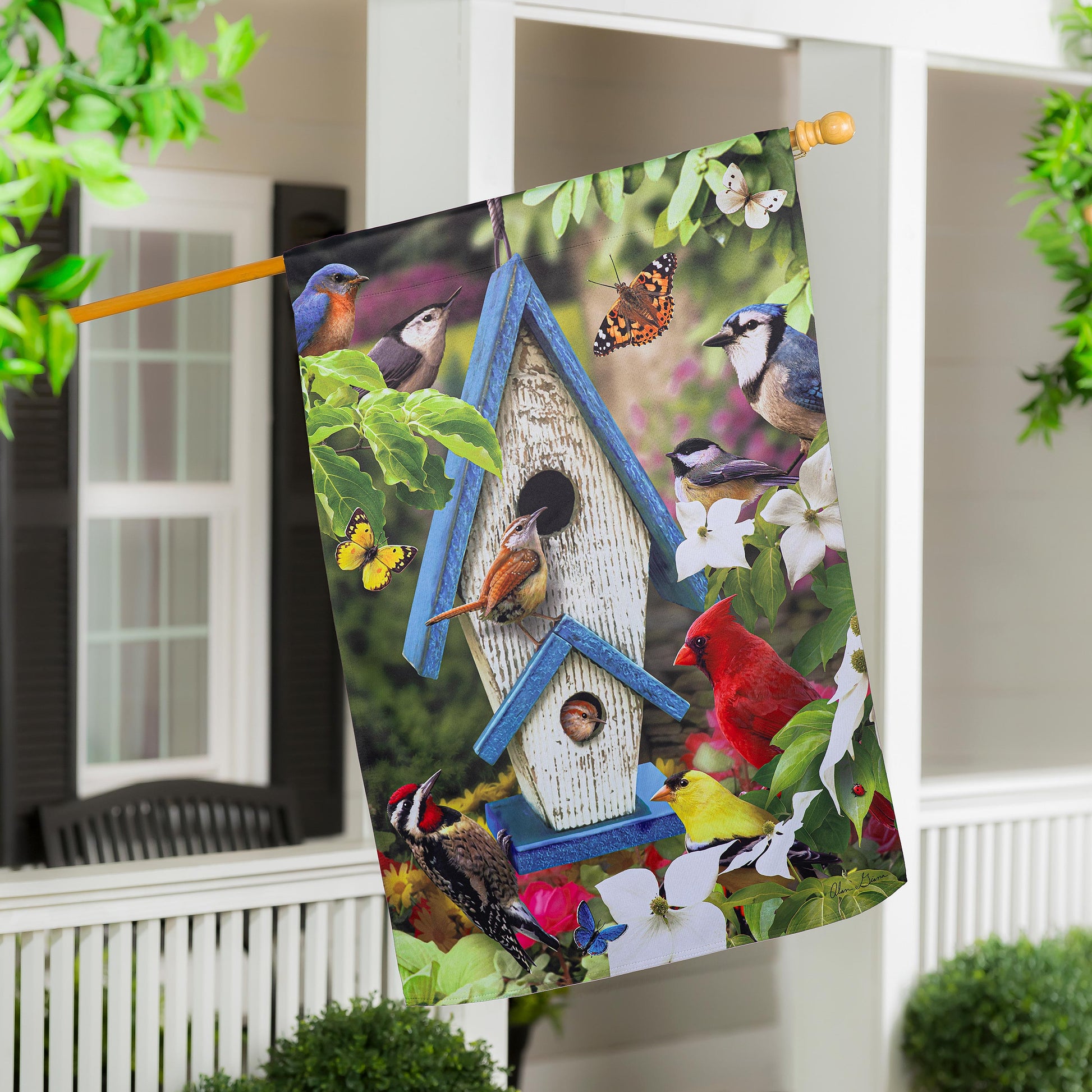 Summer Song Suede House Flag with vibrant birds and butterflies on a wooden rod on Tampa Home & Garden Store