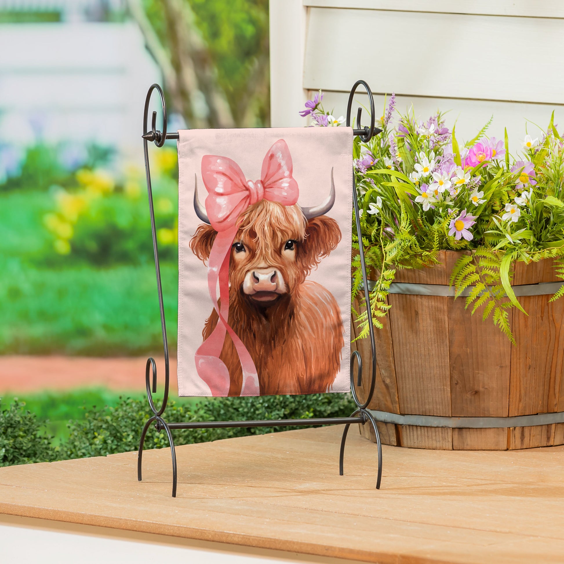 Blossom The Bowtiful Highland Cow Burlap Garden Flag with pink bow on a metal stand on Tampa Home & Garden Store