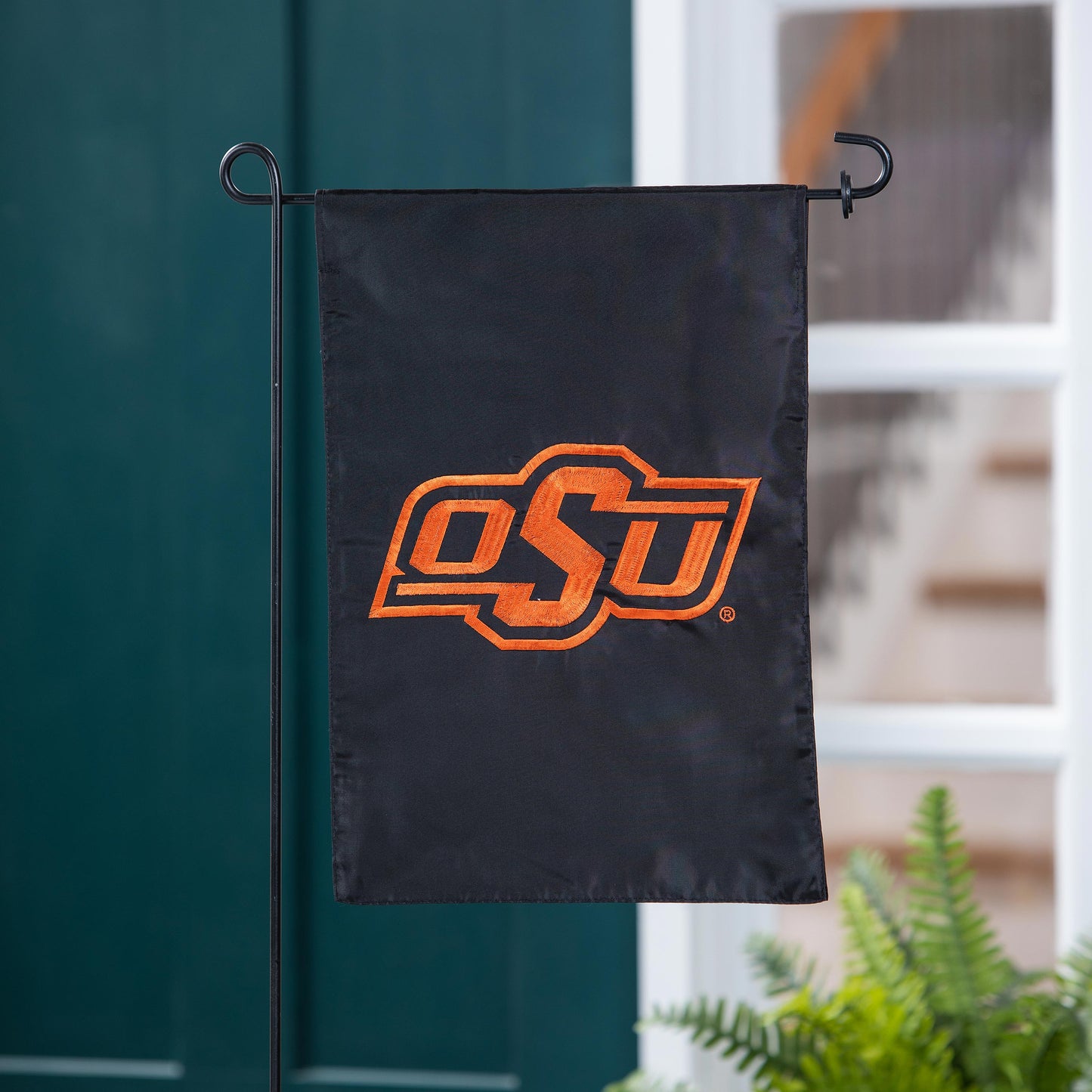 Applique flag Oklahoma State University on fabric with orange OSU emblem, on black metal stand on Tampa Home & Garden Store
