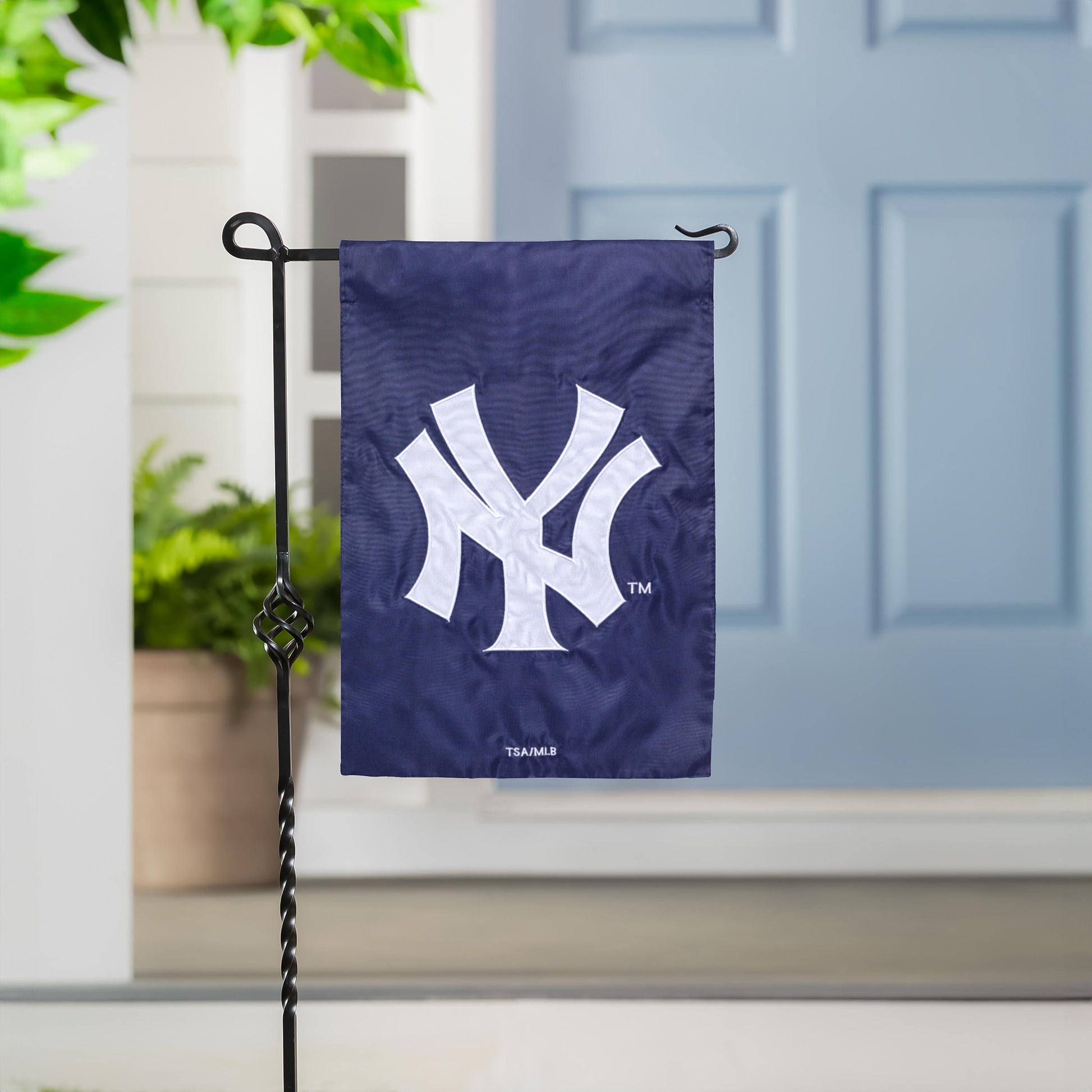 New York Yankees applique flag on navy fabric with white NY logo on a black metal stand on Tampa Home & Garden Store