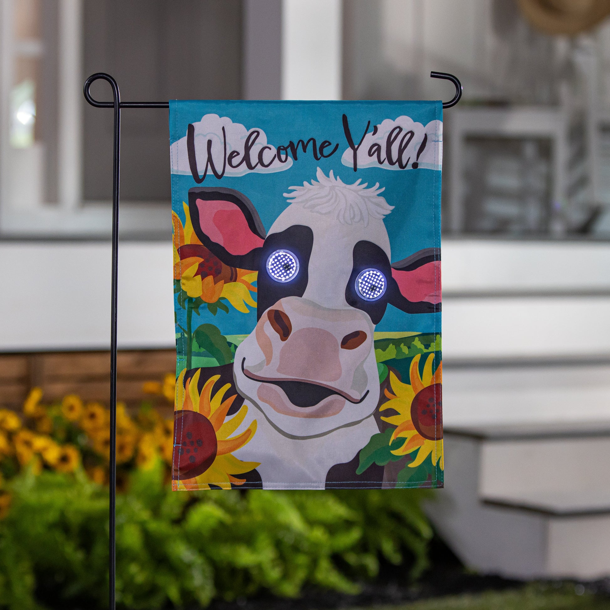 Animated Welcome Y'all Cow Applique Lighted Garden Flag with background cow art on stand on Tampa Home & Garden Store