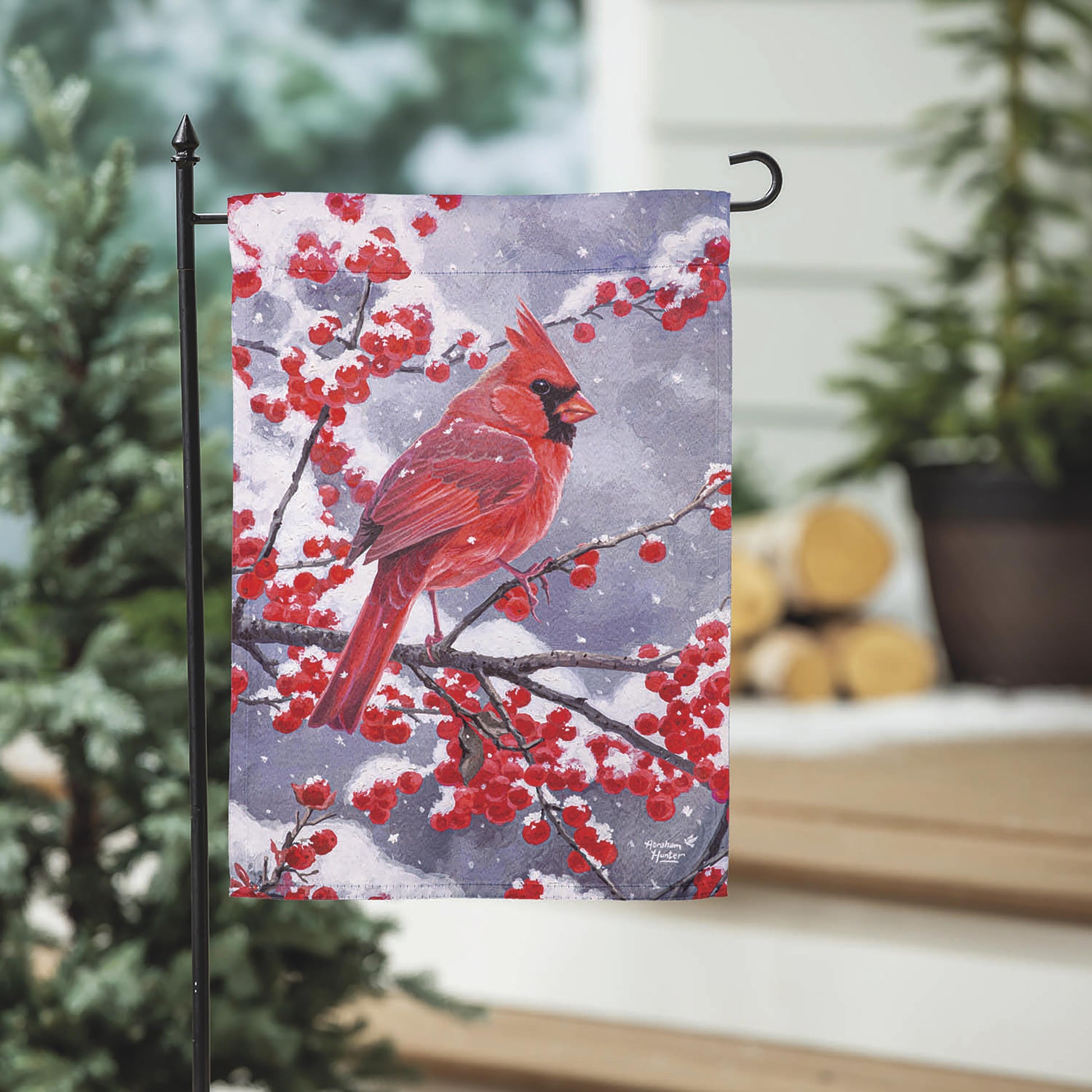 Red Cardinal Suede Garden Flag on black metal stand with berry branches on Tampa Home & Garden Store