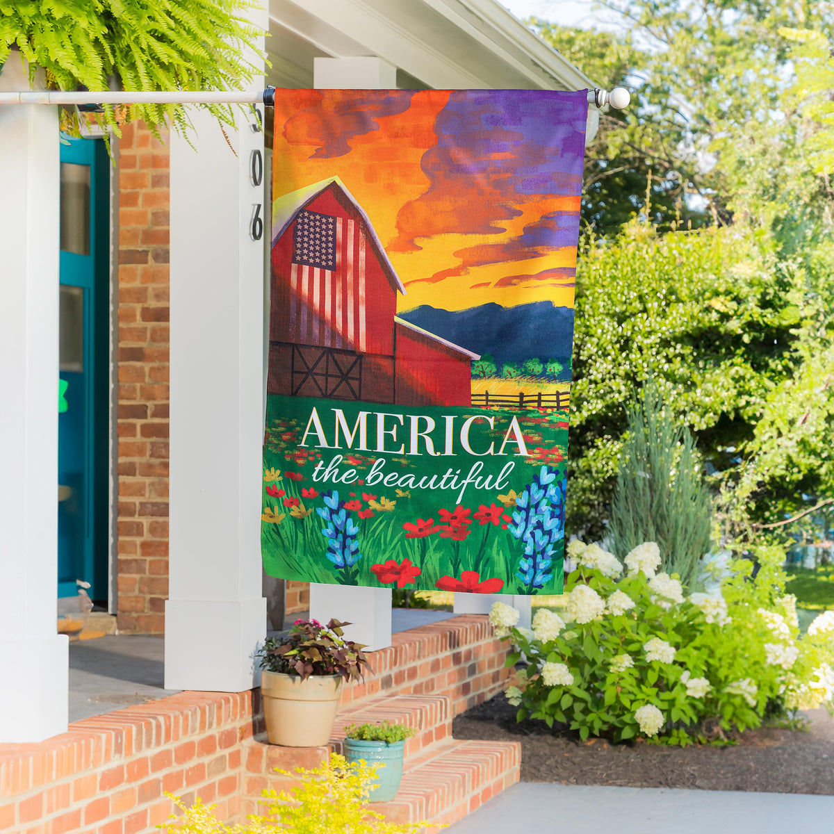 America the Beautiful burlap house flag with patriotic barn in orange purple hues on Tampa Home & Garden Store