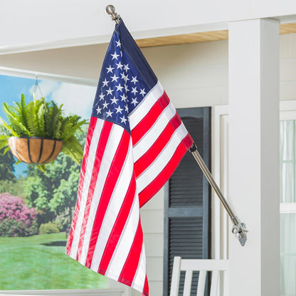 Extendable metal flag pole with silver finish displays an American flag on a white porch on Tampa Home & Garden Store