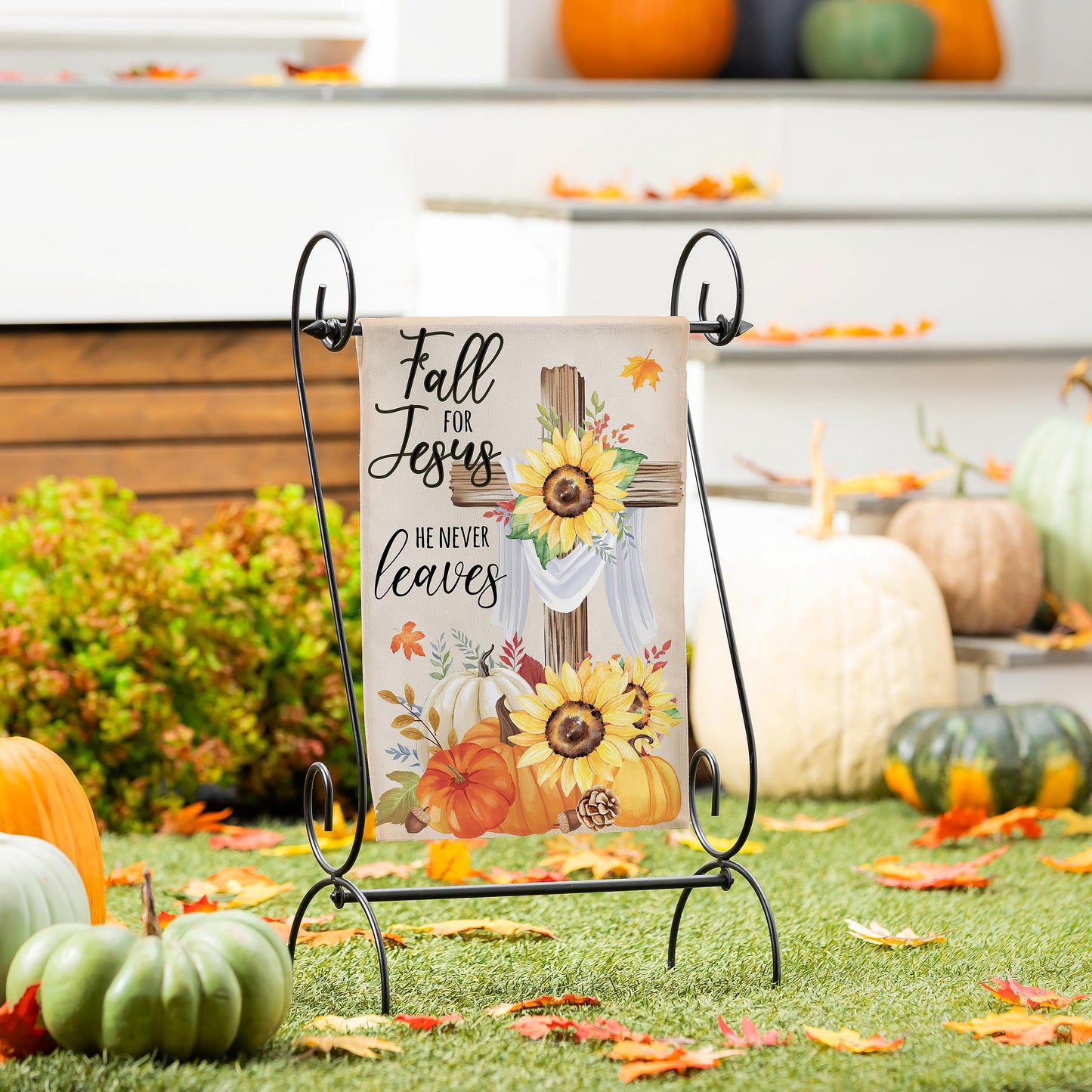 He Will Never Leave suede garden flag on a black metal stand with autumn leaves on Tampa Home & Garden Store