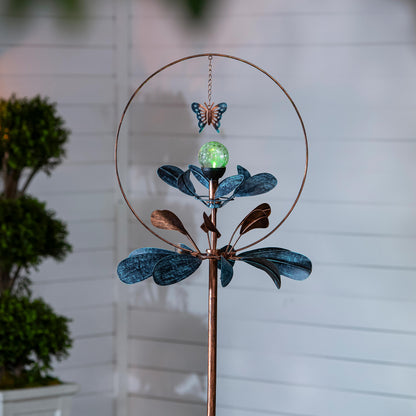 Solar metal wind spinner with copper ring, teal petals, butterfly accent, green orb on Tampa Home & Garden Store