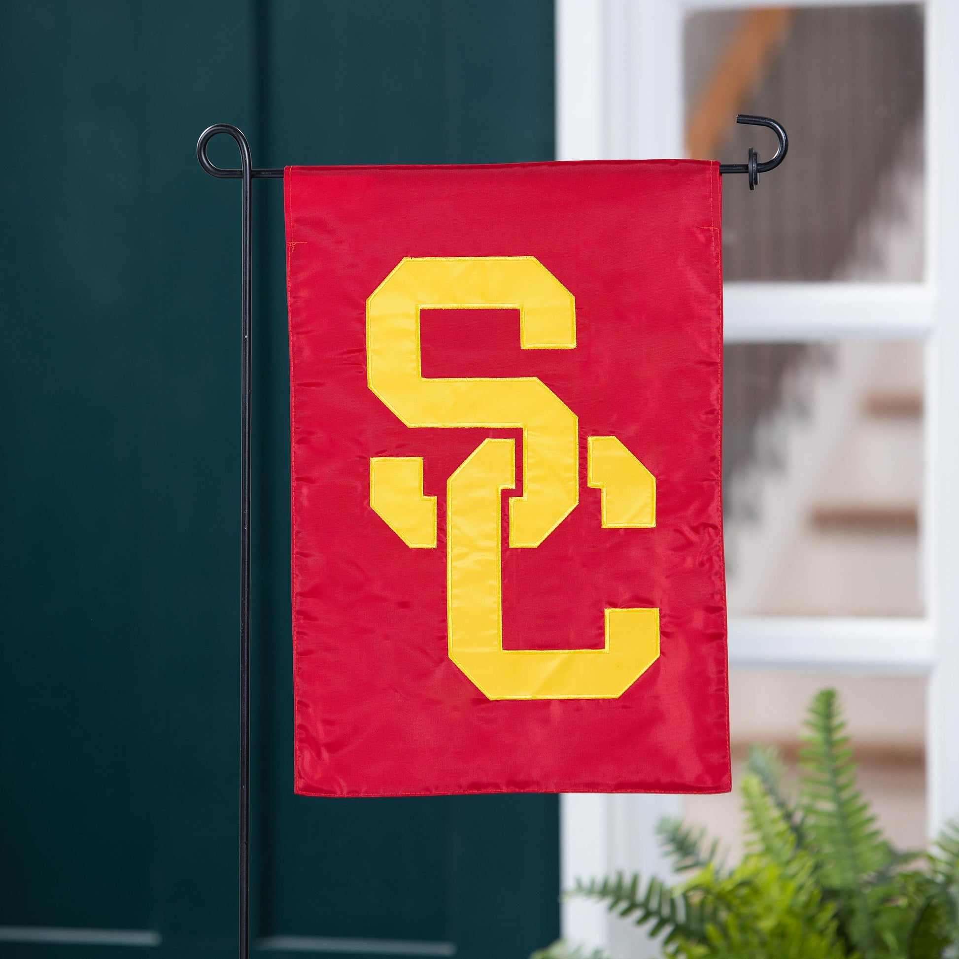 USC Applique Garden Flag by Evergreen Enterprises red with yellow letters on black metal stand on Tampa Home & Garden Store