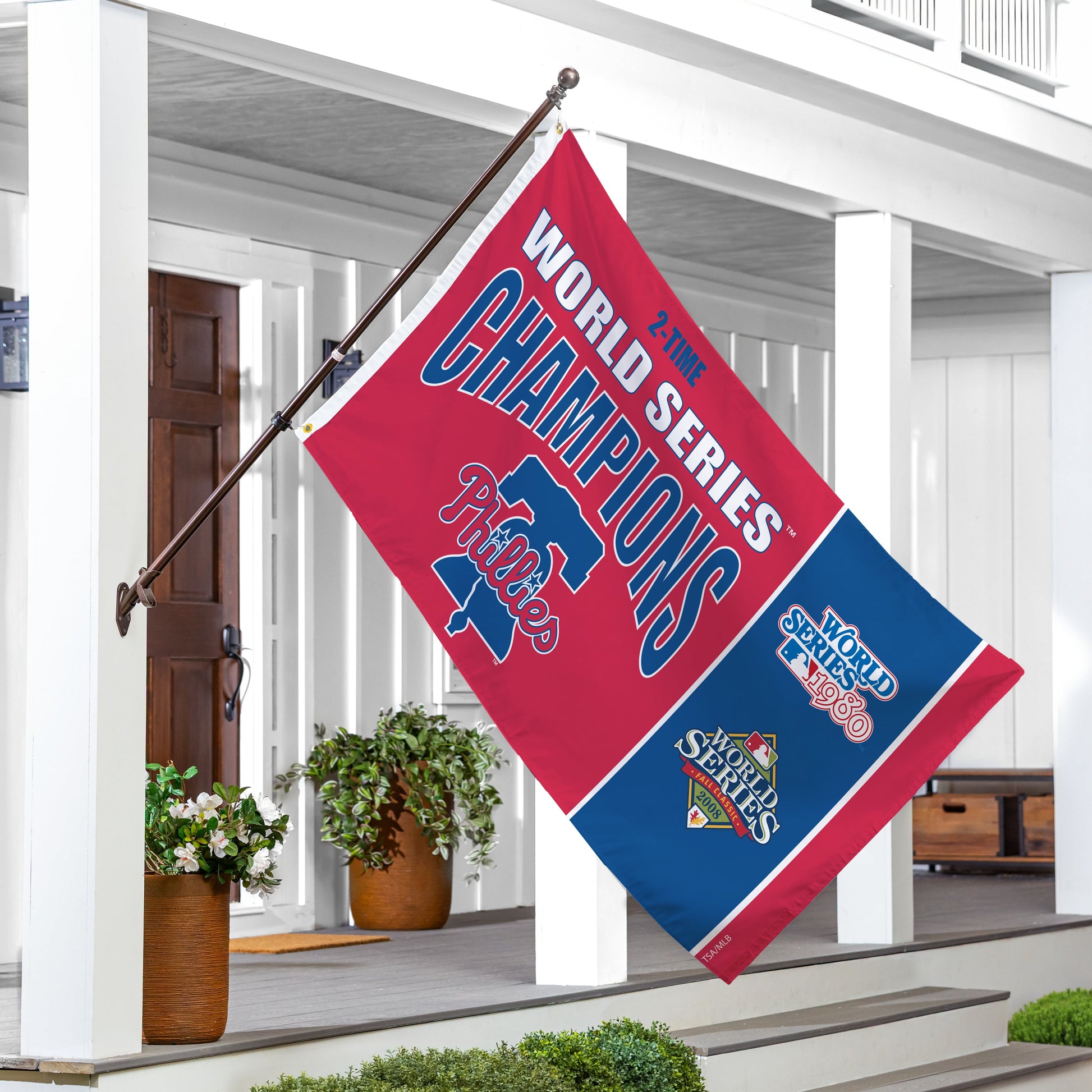 Philadelphia Phillies 3x5 single-sided flag with 2 grommets on a flagpole, displayed on a porch on Tampa Home & Garden Store