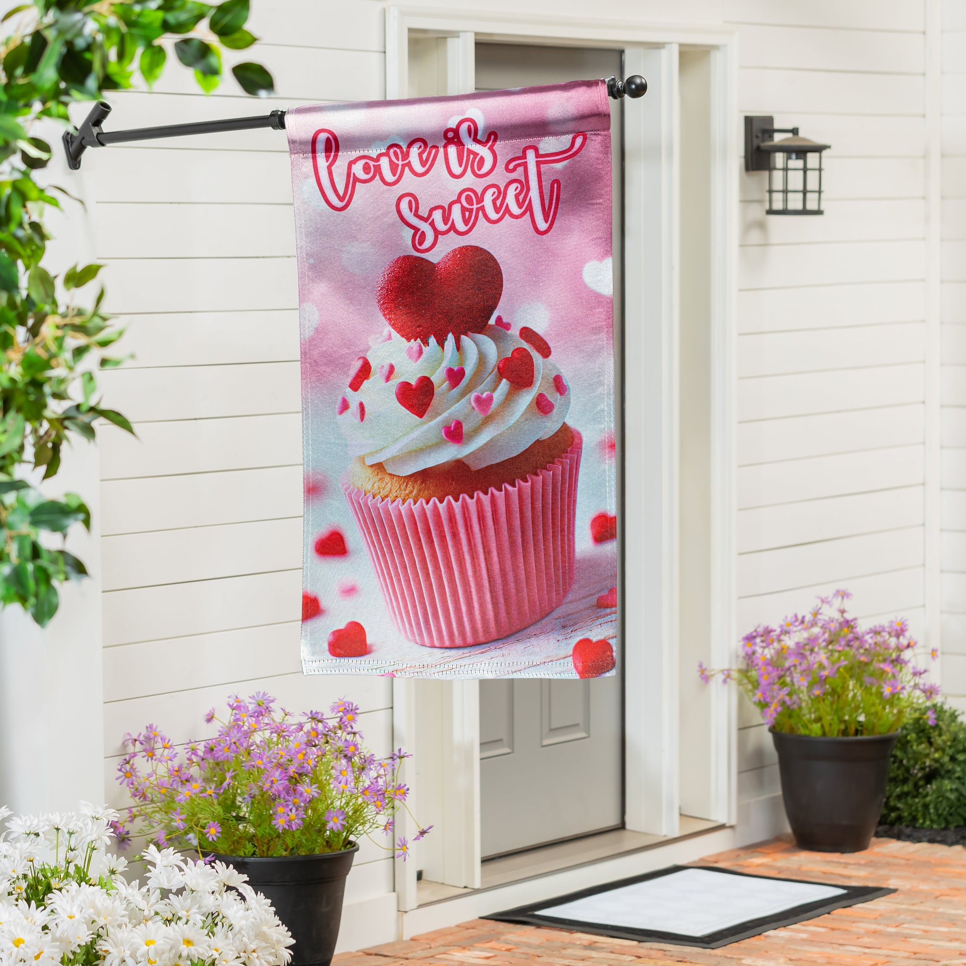 Cupcake Of Love Lustre House Flag pink cupcake with hearts on a metal arm by white siding porch on Tampa Home & Garden Store