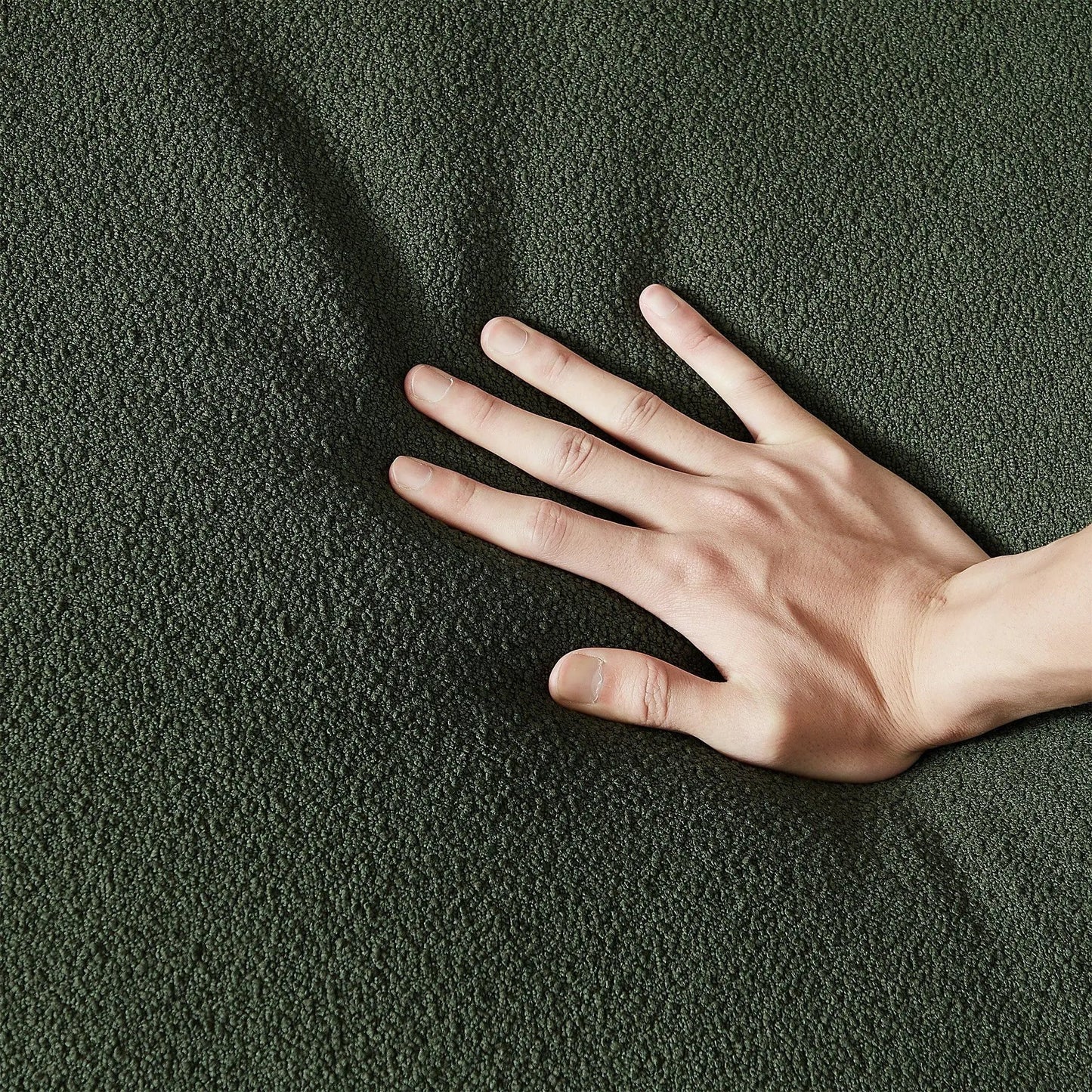 Dylan Modern French Boucle Sofa fabric close-up in dark green boucle with hand for scale on Tampa Home & Garden Store