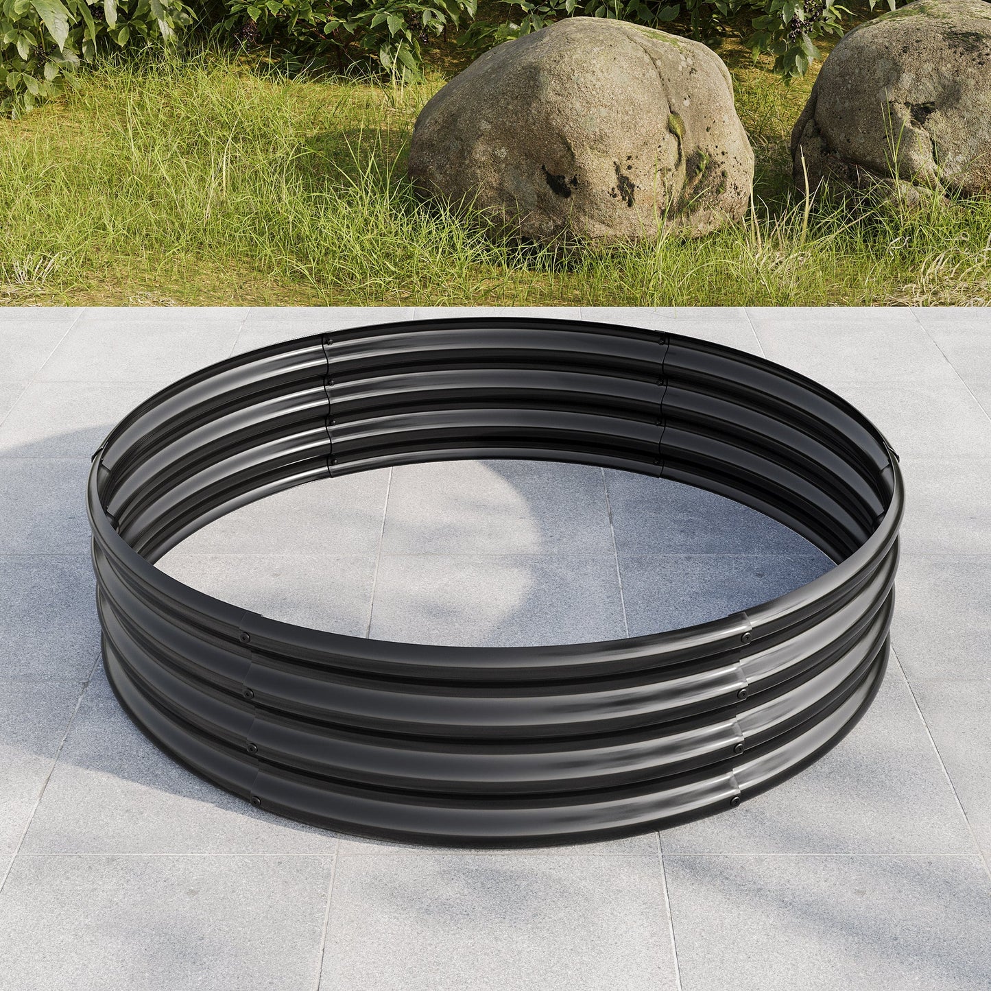 Large black circular metal coil on gray tiled ground with grass and rocks in background on Tampa Home & Garden Store