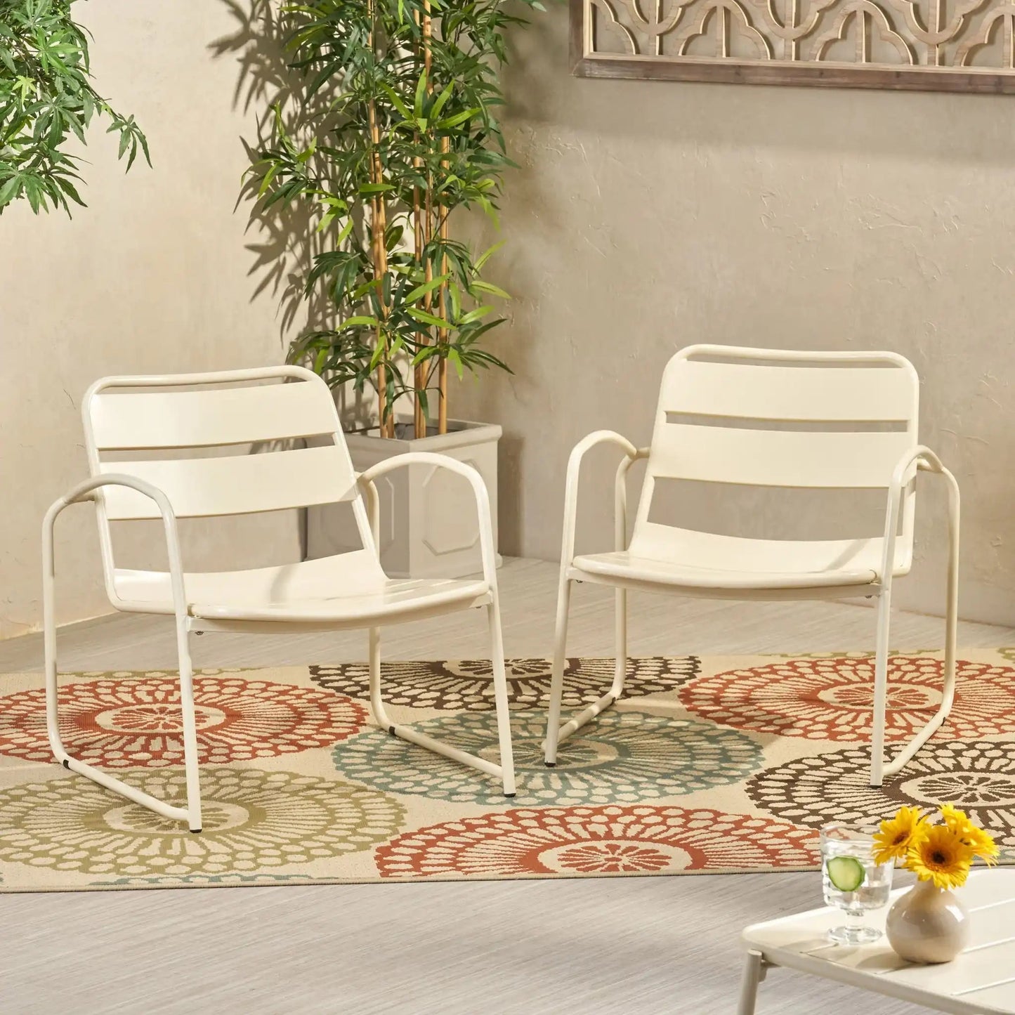 Conrad Outdoor Chair white metal arm chairs on a patio with a colorful circular rug on Tampa Home & Garden Store