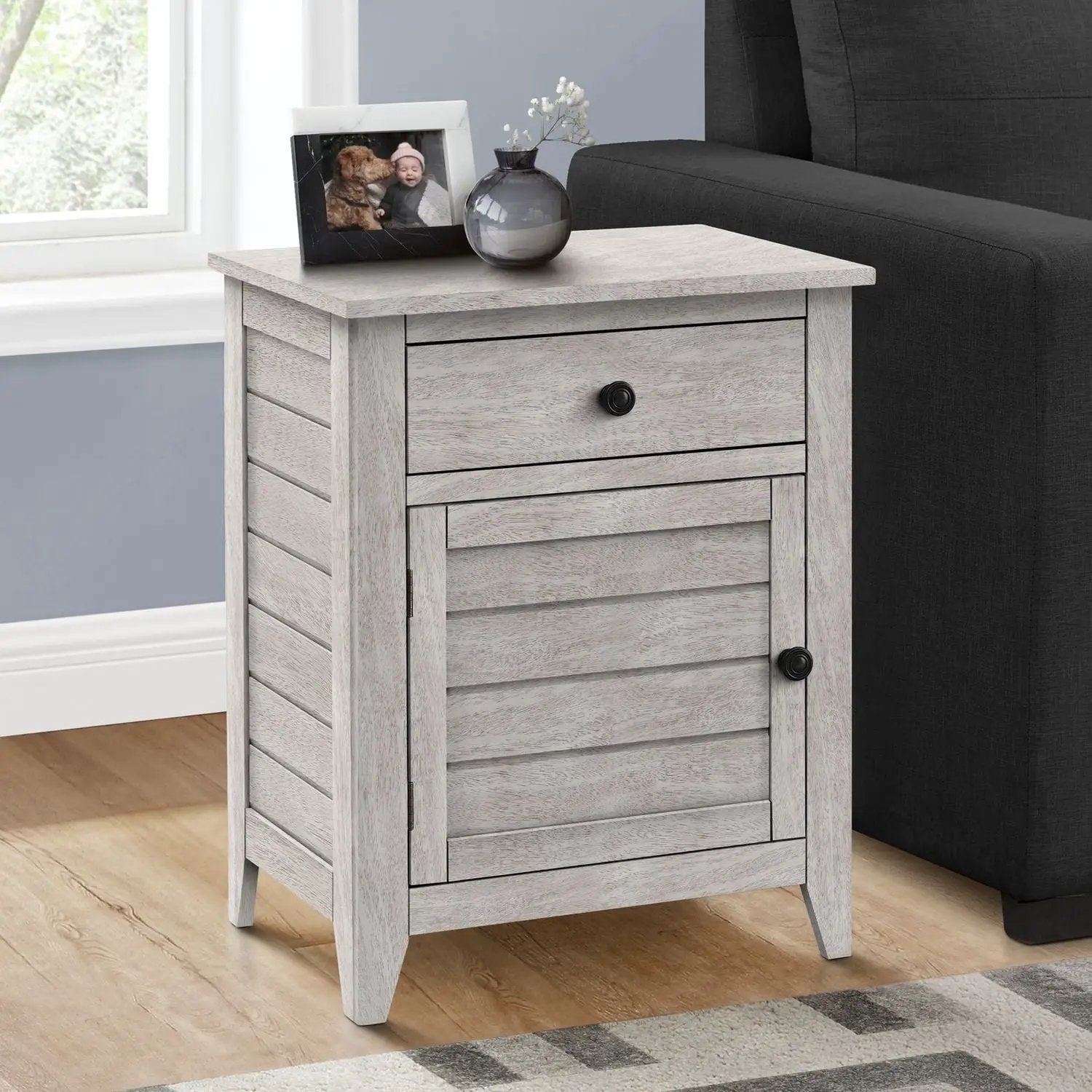 Accent nightstand with storage drawer and slatted cabinet in weathered gray beside a dark sofa on Tampa Home & Garden Store