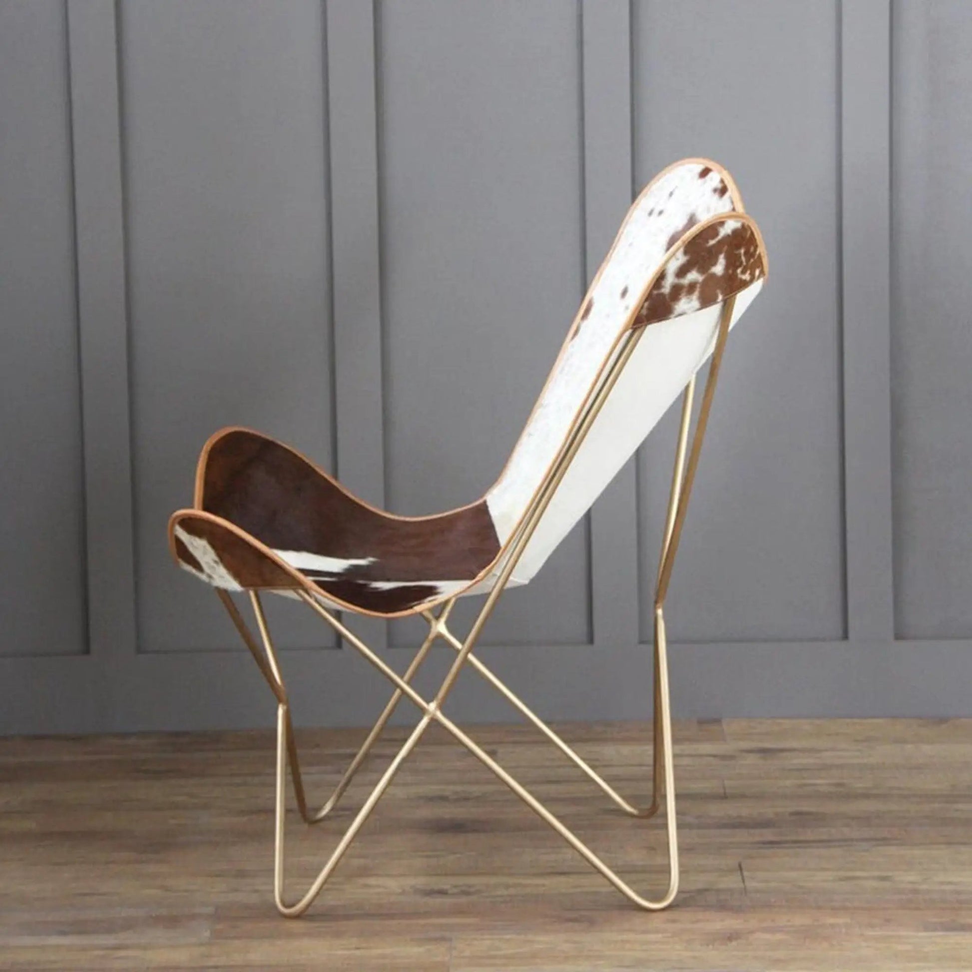 The Swiss Butterfly Chair with cowhide seat on a slim gold metal frame on Tampa Home & Garden Store