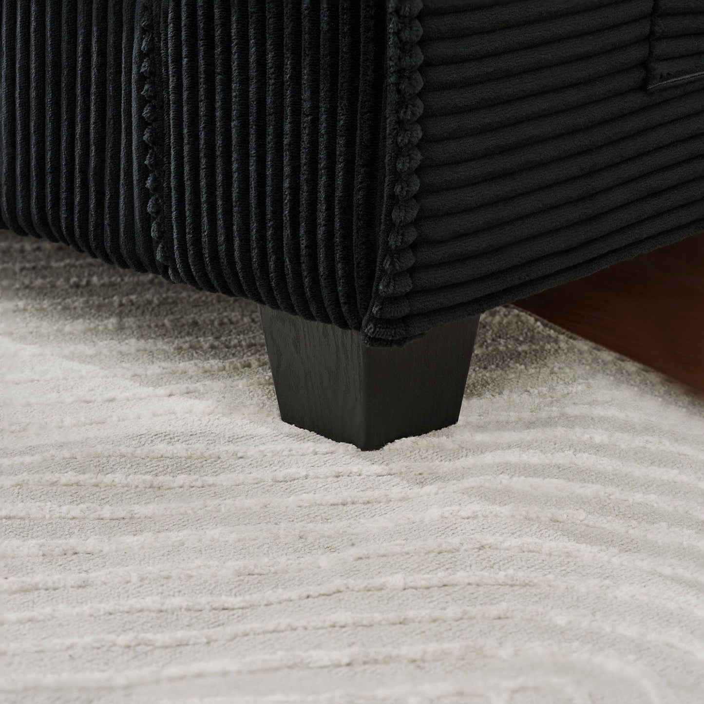 Storage bench with black ribbed corduroy upholstery and tassel trim wood leg on Tampa Home & Garden Store